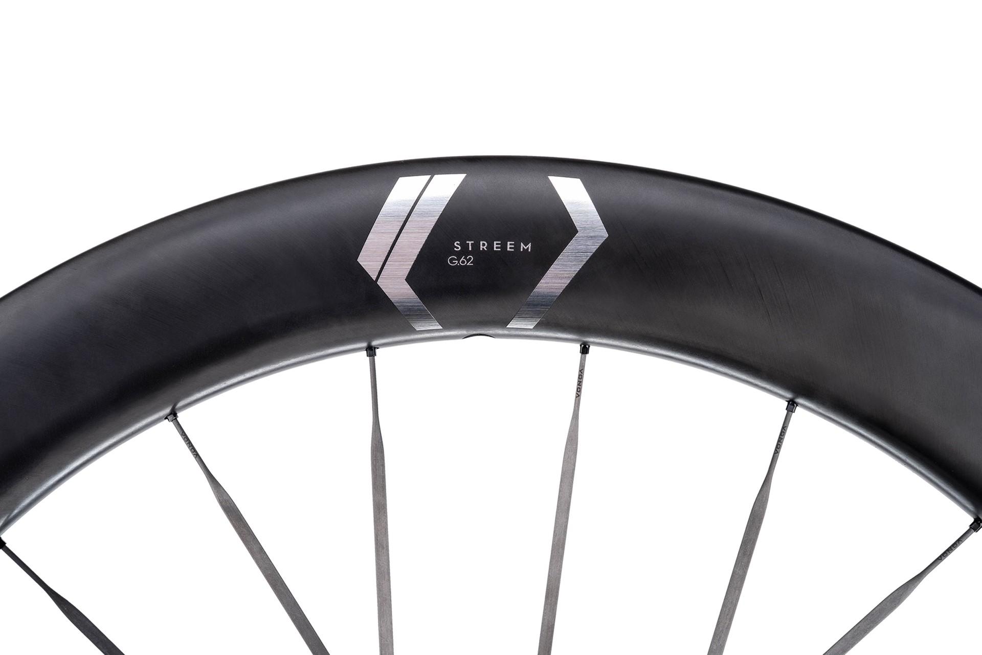 Close-up of a black NEWMEN Streem wheel rim with a deep carbon profile and thin spokes.