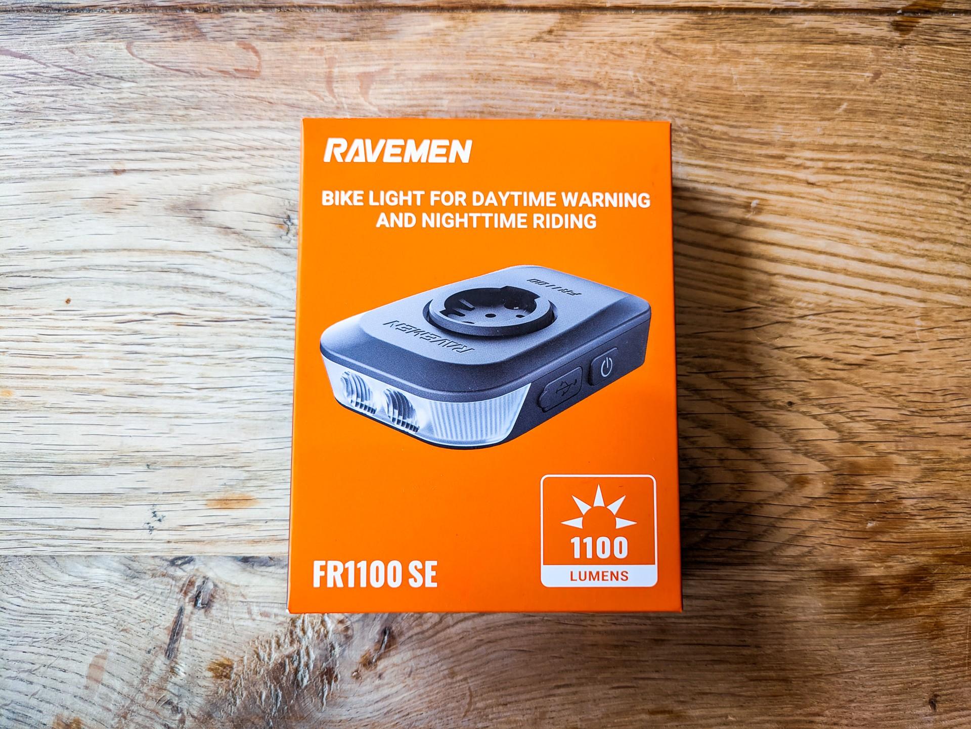 Ravemen FR1100 SE bike light box on a wooden surface, showing the flat black light and 1,100-lumen label