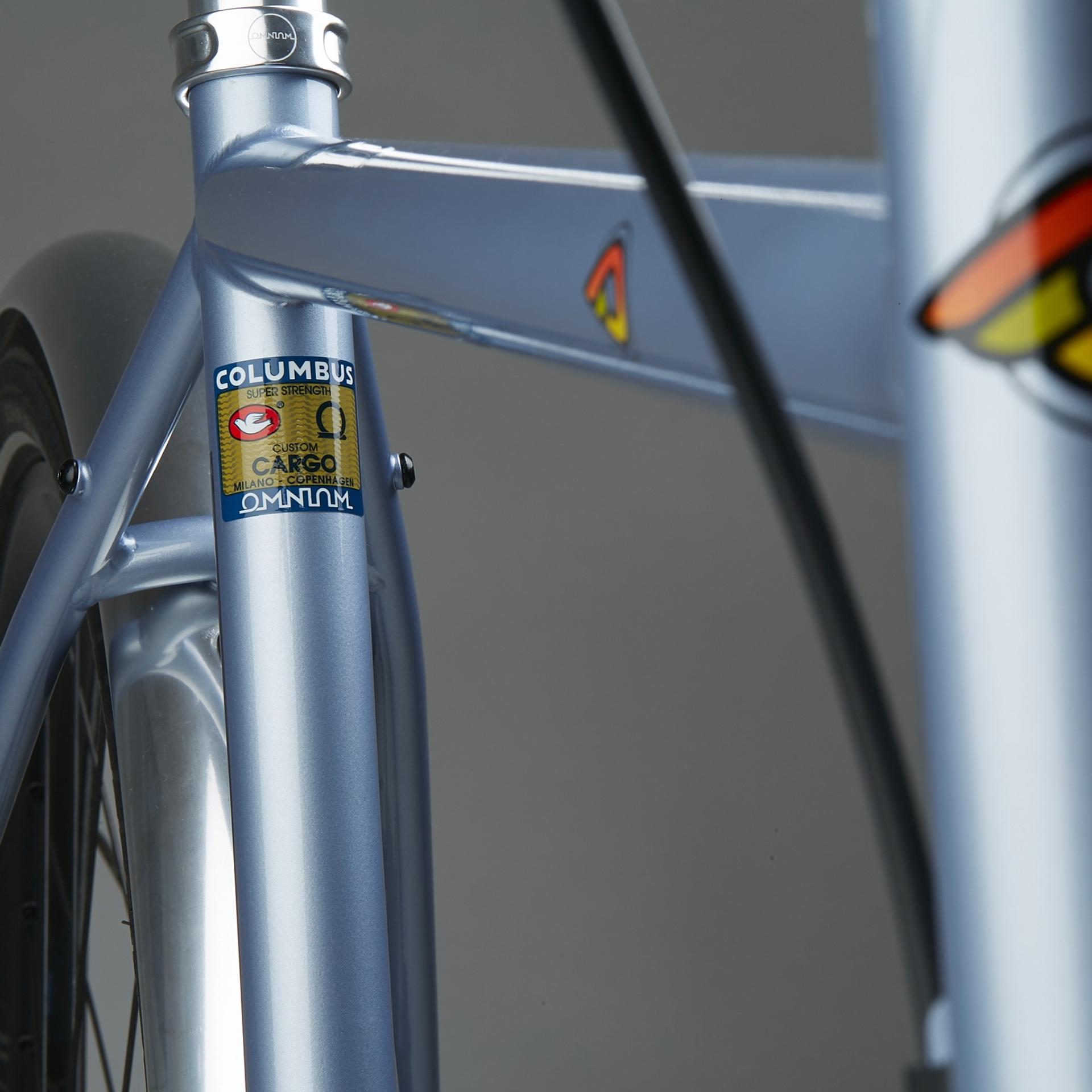 Close-up of a blue racing bicycle frame with Columbus and Omnium logos in an indoor setting