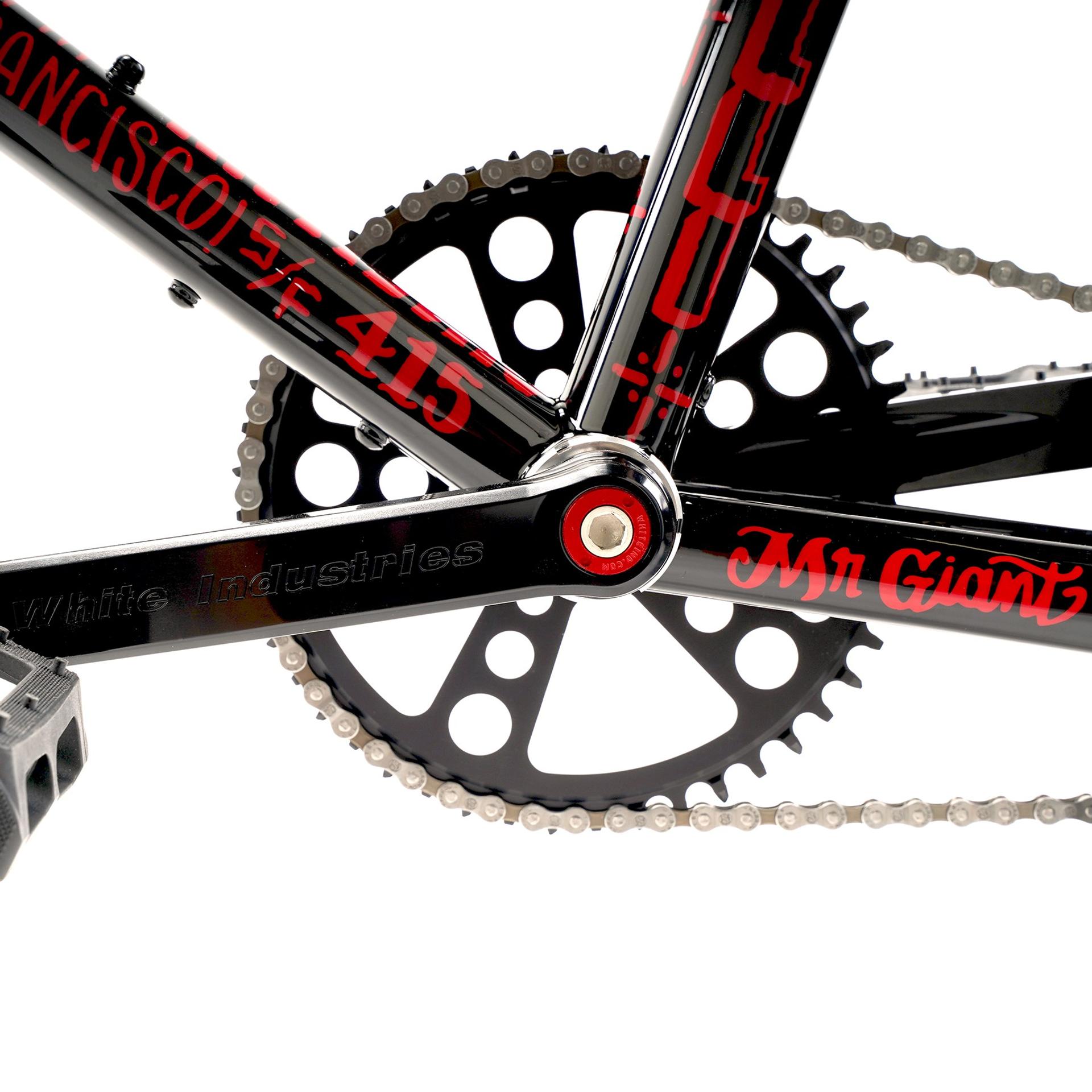 Close-up of the black Cinelli Tutto Mini frame, chainring and chain, with red Mike Giant lettering.