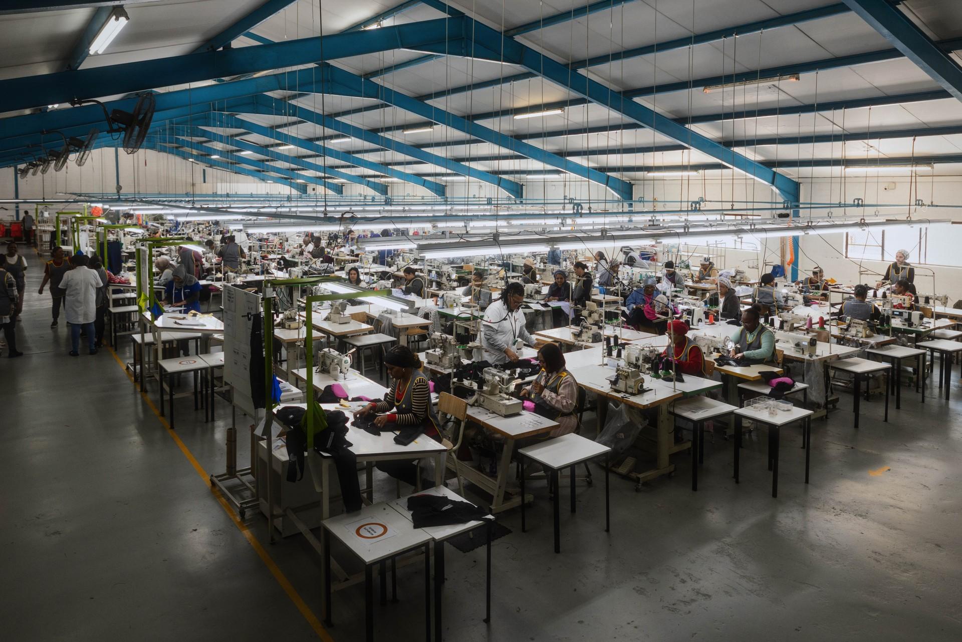 Large indoor electronics assembly line with workers seated at multiple workstations
