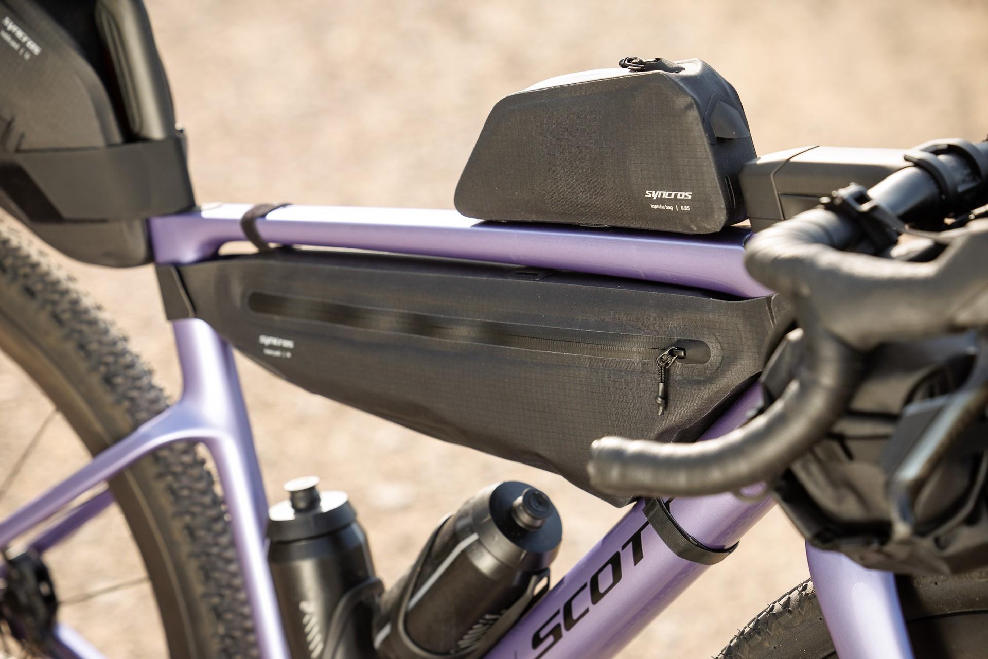 Close-up of a purple Scott Addict Gravel bike with integrated frame storage, a top-tube bag and drop handlebars