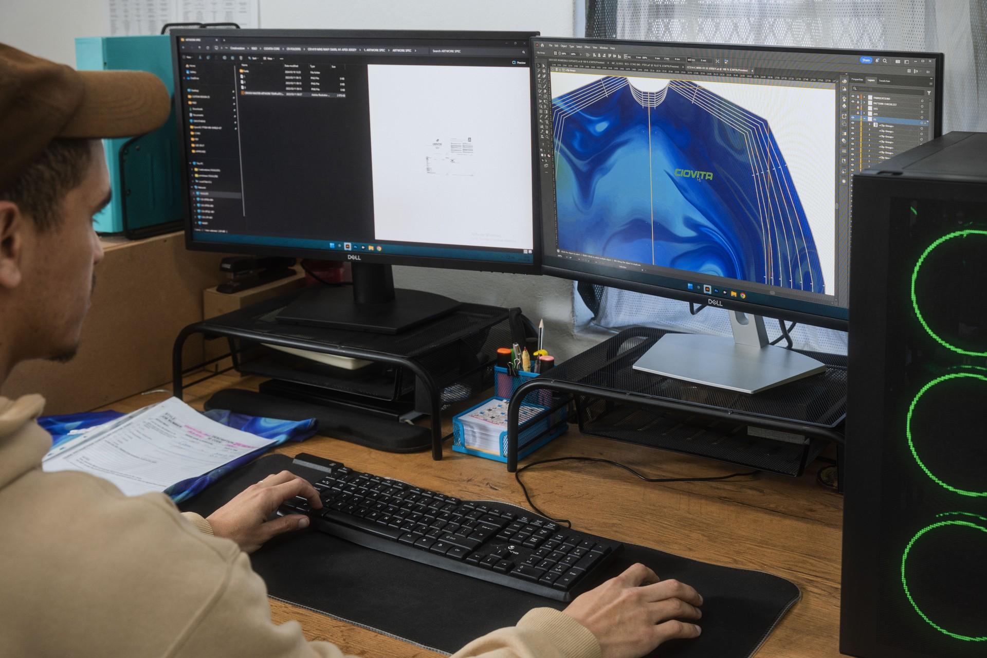Programmers at dual monitors analyze 3D computer graphics in a desktop workstation lab