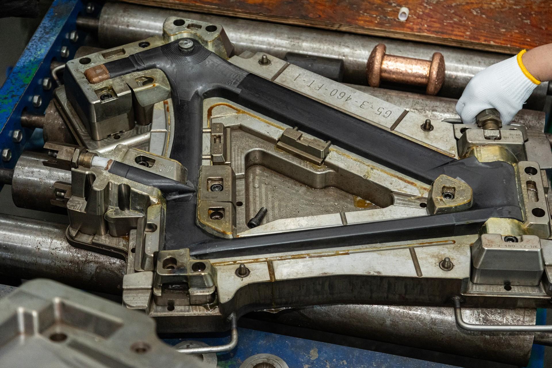 Mechanic’s gloved hands working inside a dismantled firearm receiver and action components
