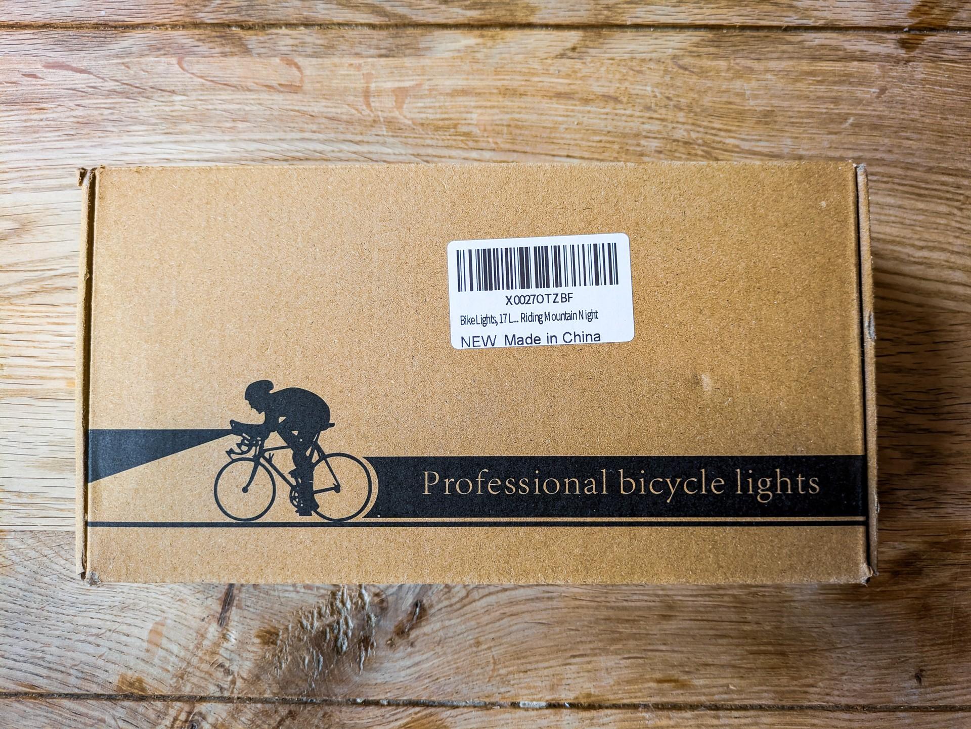 Sioyio W617 bicycle light box on a wooden floor, labelled “Professional bicycle lights” with a cyclist graphic.