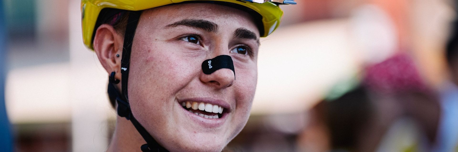 Paula Blasi smiles in a yellow helmet and race kit during the Tour de France Femmes.