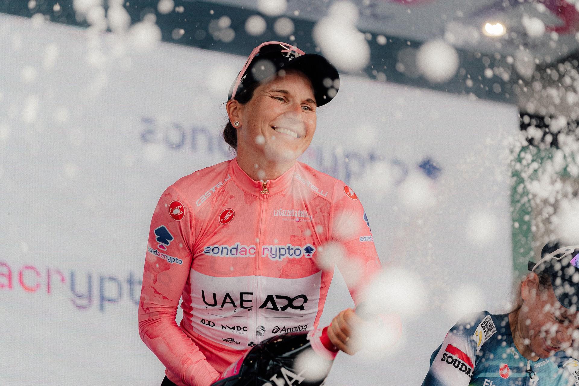 Elisa Longo Borghini celebrates with champagne on the Giro d'Italia Women podium.