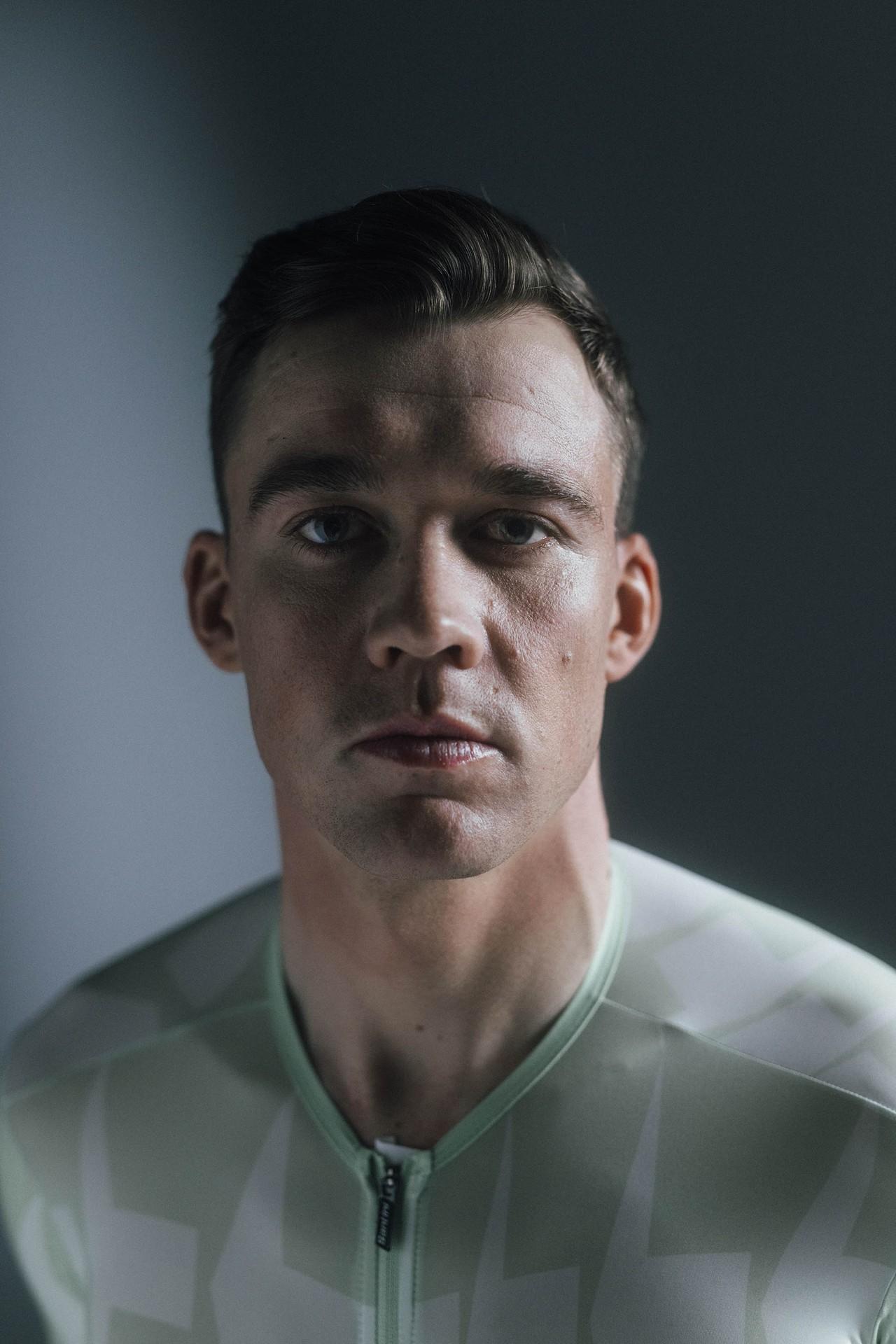 Close-up studio portrait of Danish professional cyclist Mads Pedersen looking intensely at the camera.