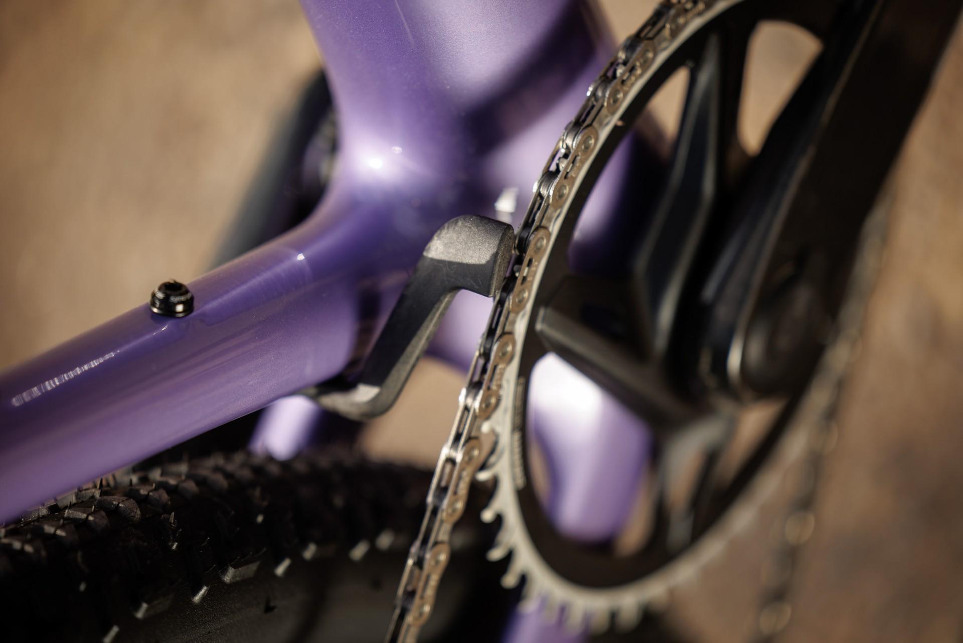 Close-up of the purple Scott Addict Gravel’s narrow driveside chainstay beside its chainring and chain