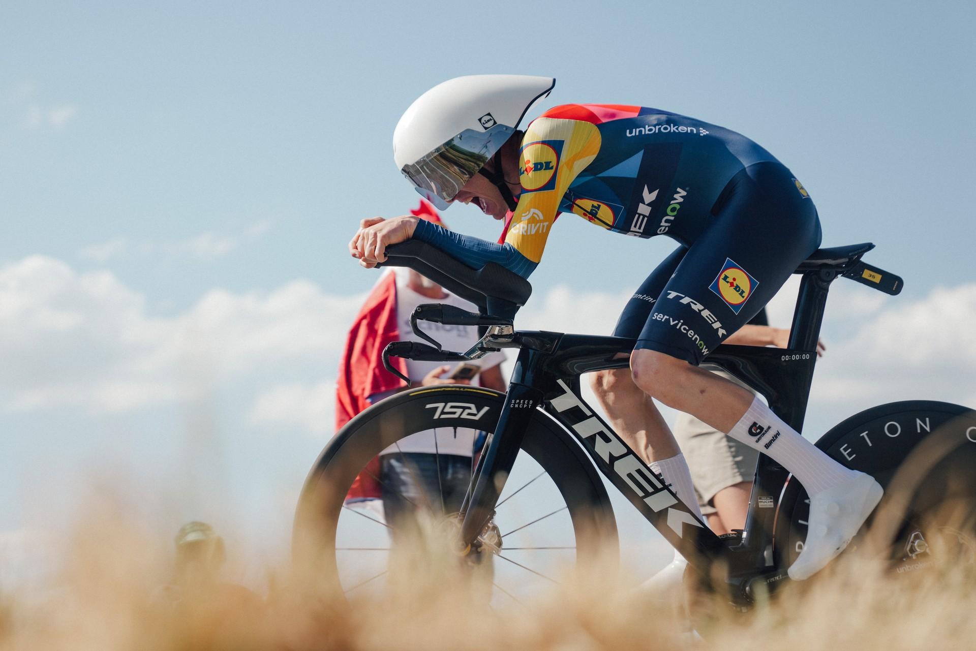 Mattias Skjelmose rides a time trial in the Tour de France, leaning forward in aerodynamic position.