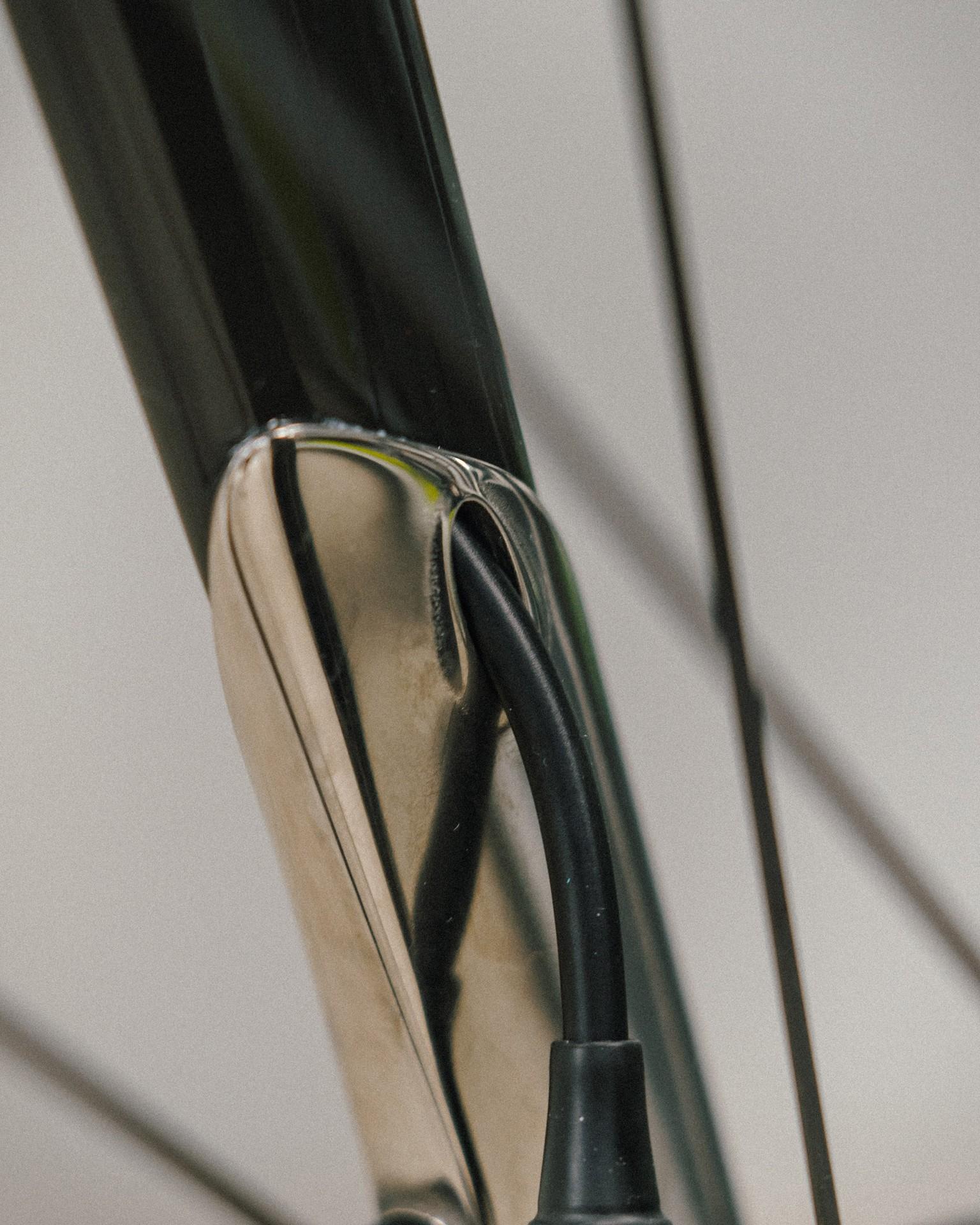 Close-up of a bicycle fork and wheel rim with reflective detail on the spokes