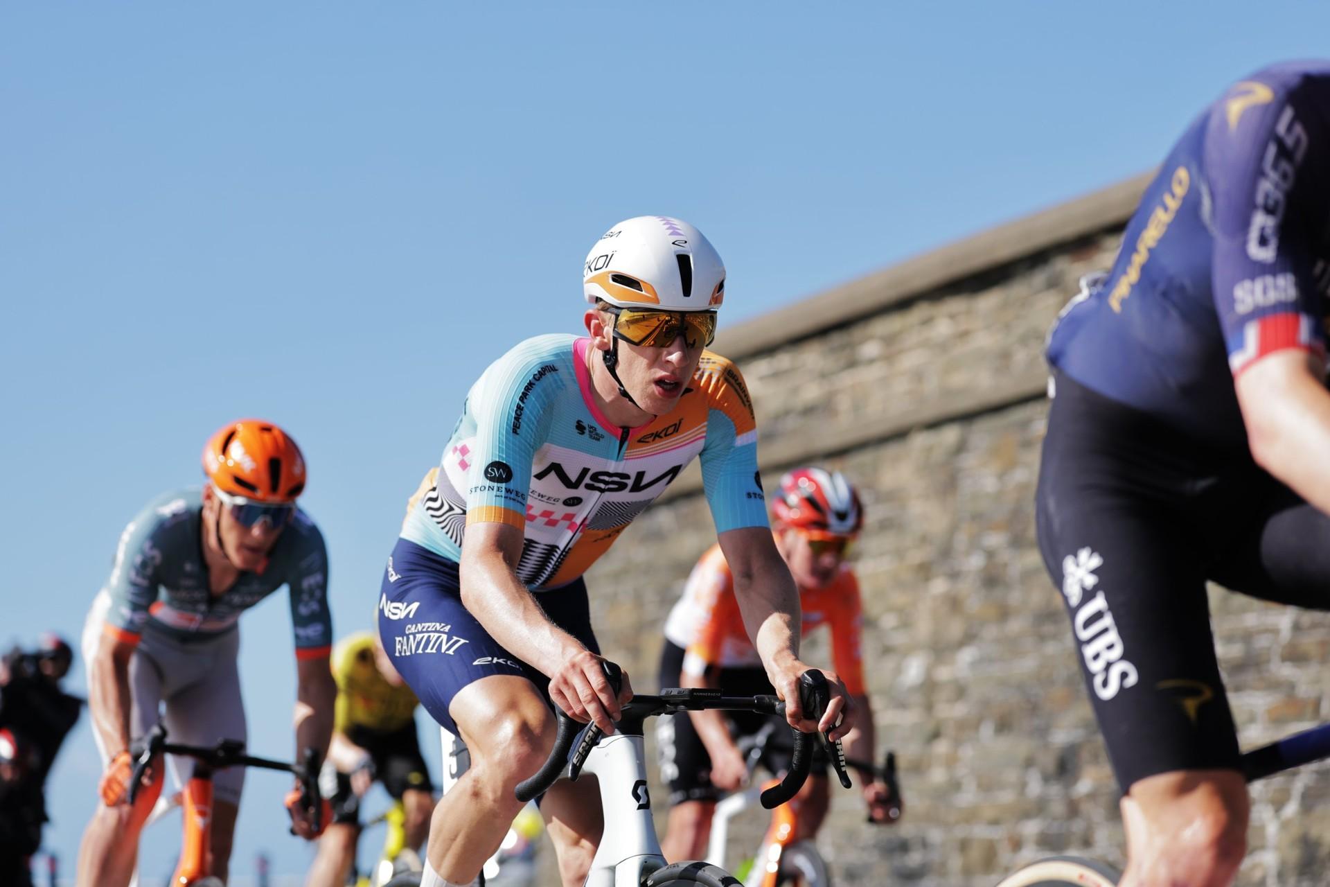 Lewis Askey of NSN Cycling Team rides uphill with other cyclists during the Tour of Britain.