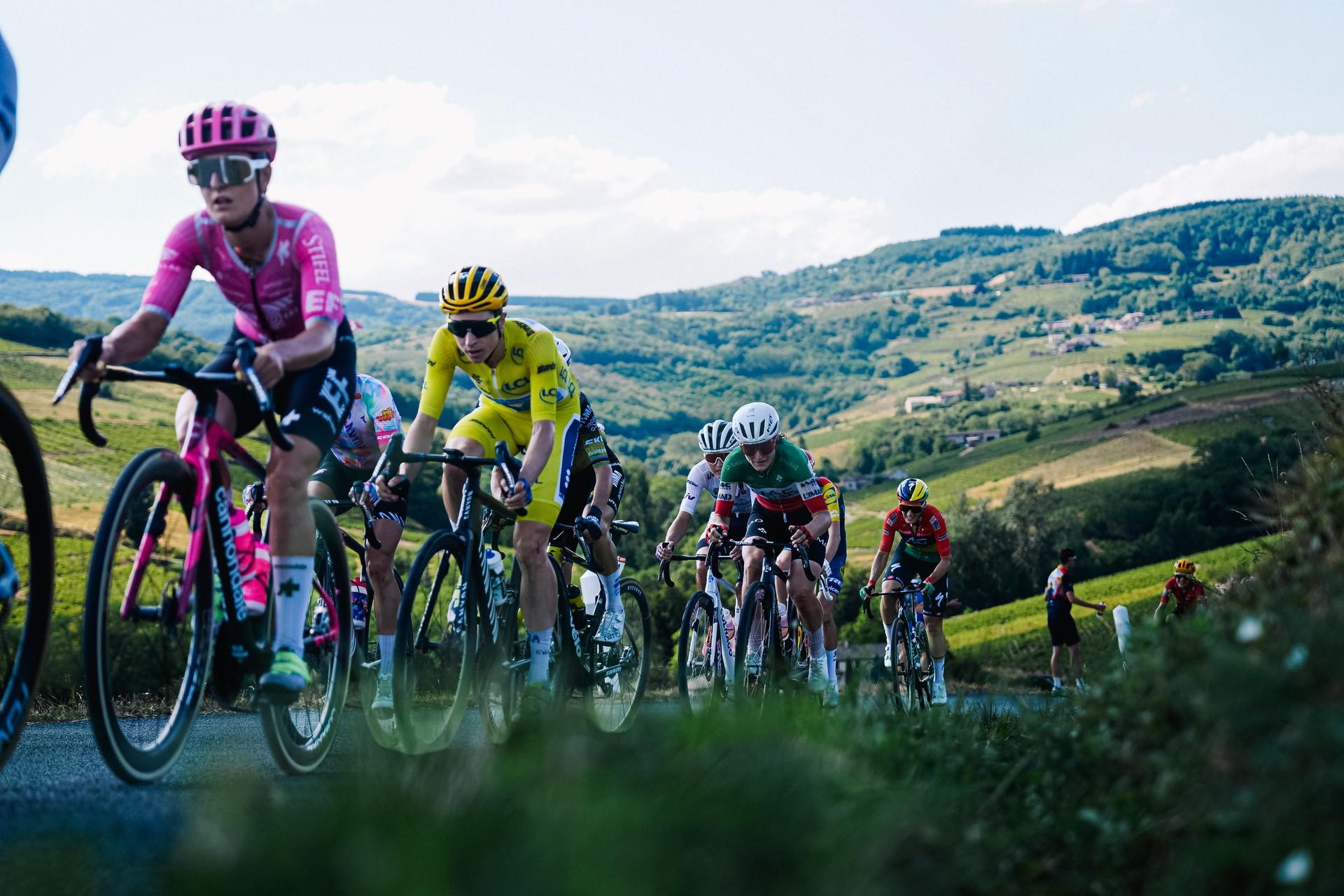 Cyclists sprint in a group on open roads during Tour de France Femmes with Zwift, Étape 5 from Macon to Belleville