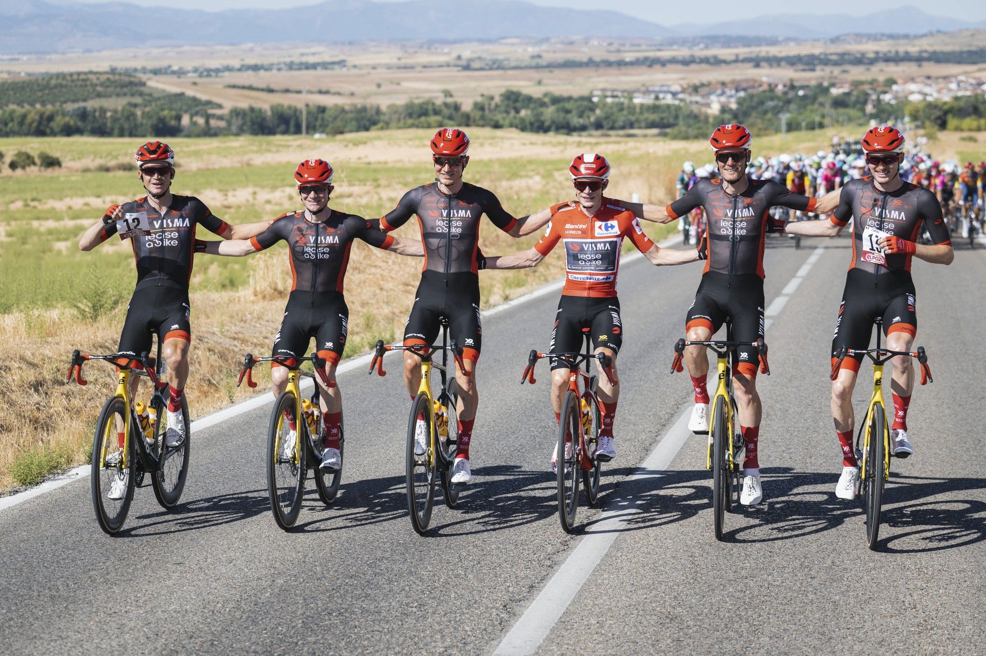 Visma team celebrates Vuelta 2025 win riding together arms raised (62 chars)