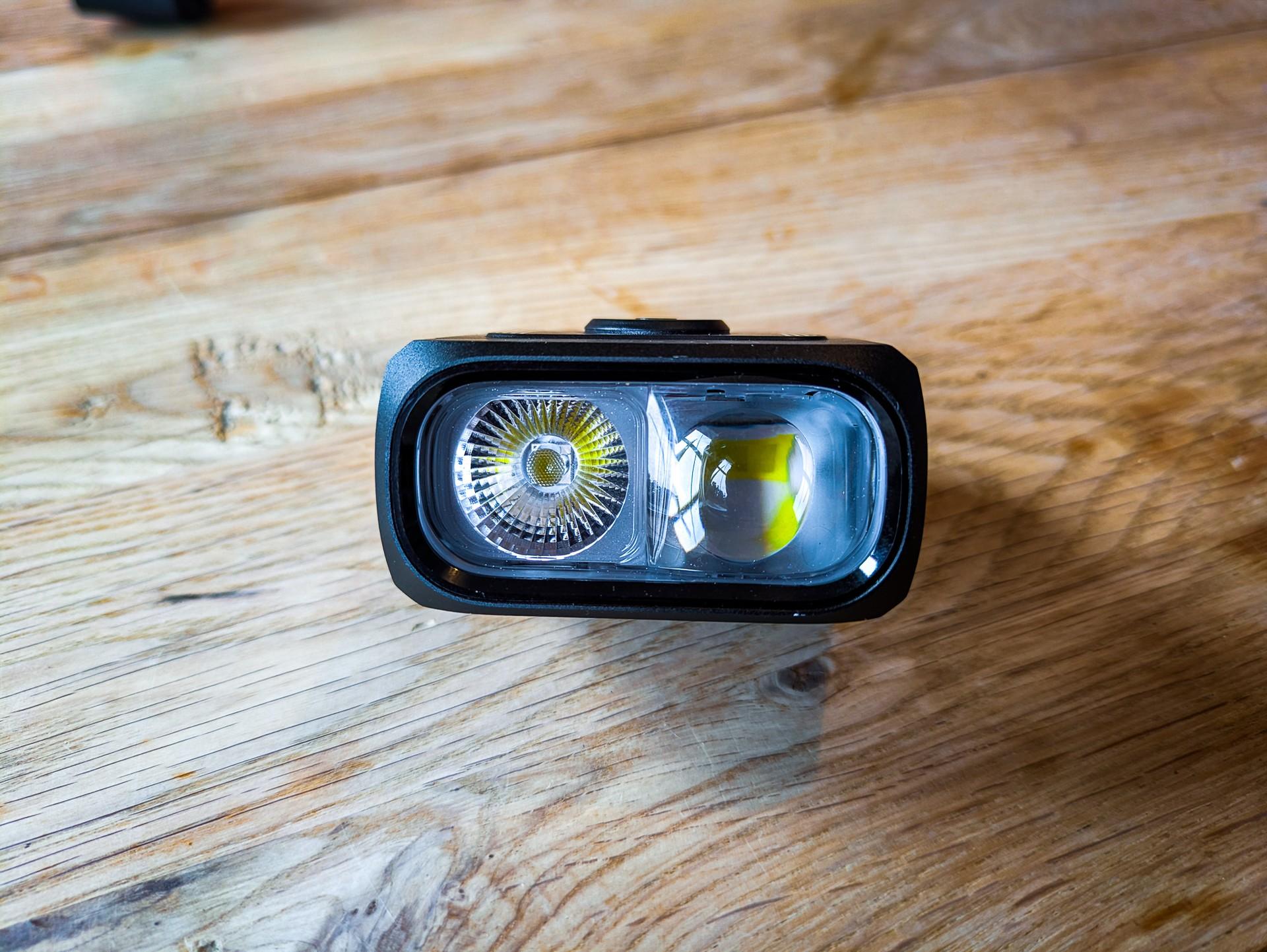 Magicshine HORI 1300 dual-lens bike light resting on a wooden surface