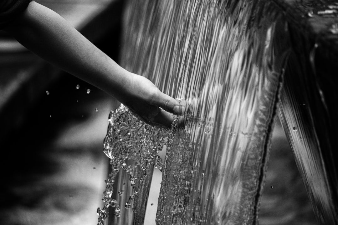 Close-up of a child's hand touching a lightweight, water-repellent fabric with a subtle texture.