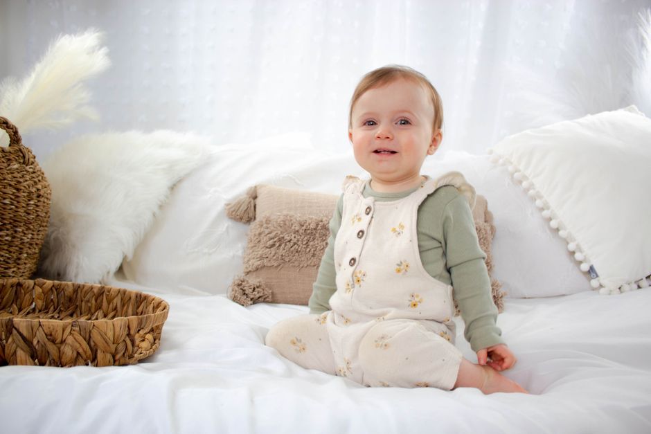 Close-up of a baby's hand gently touching a soft organic cotton fabric.
