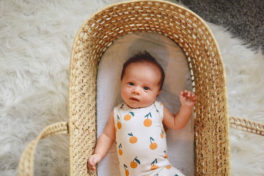 A close-up of a newborn baby comfortably wearing a soft, light-colored cotton onesie, highlighting the comfort of baby clothes.