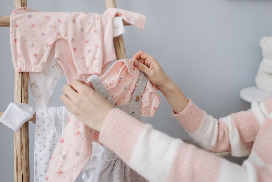 A baby wearing a cute, well-fitting outfit smiling happily.