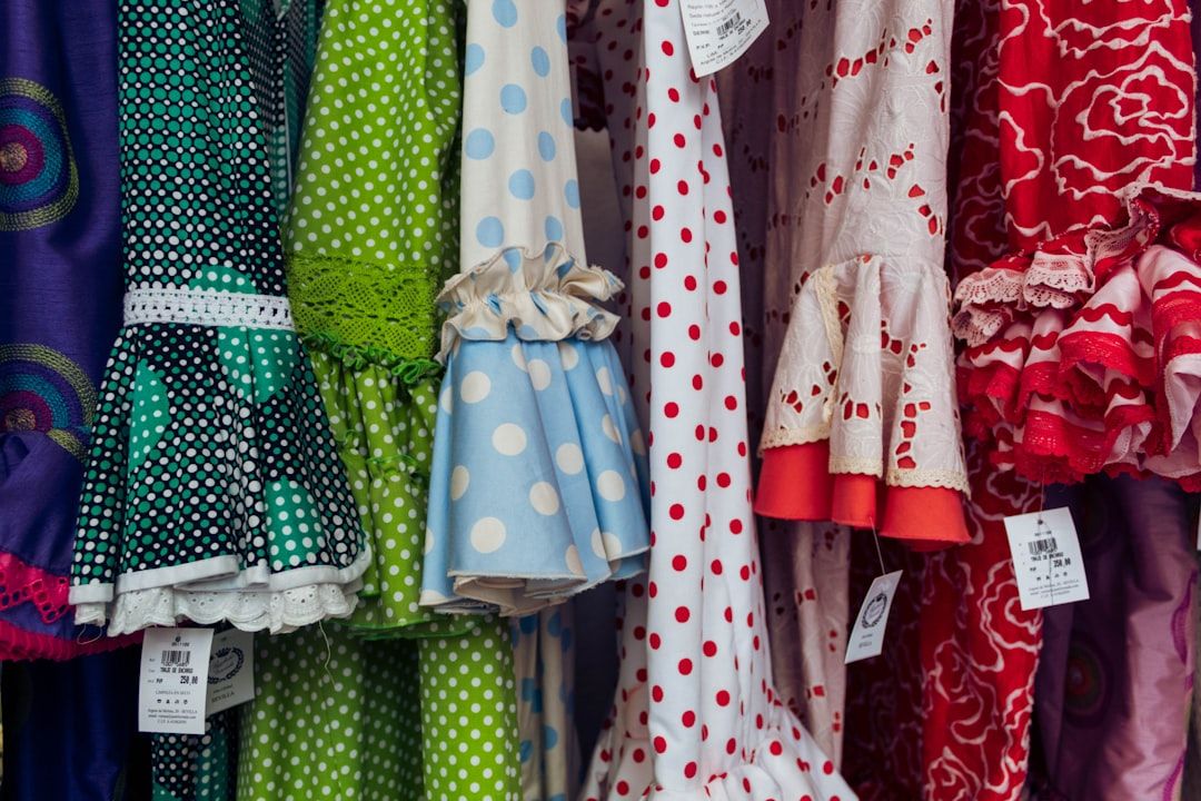 A vibrant display of various colorful and stylish party dresses for young girls.