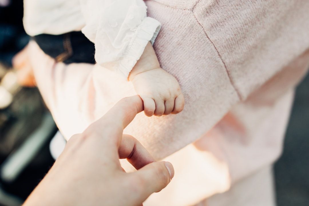 A parent comparing a size tag on a baby outfit to their infant's measurements.