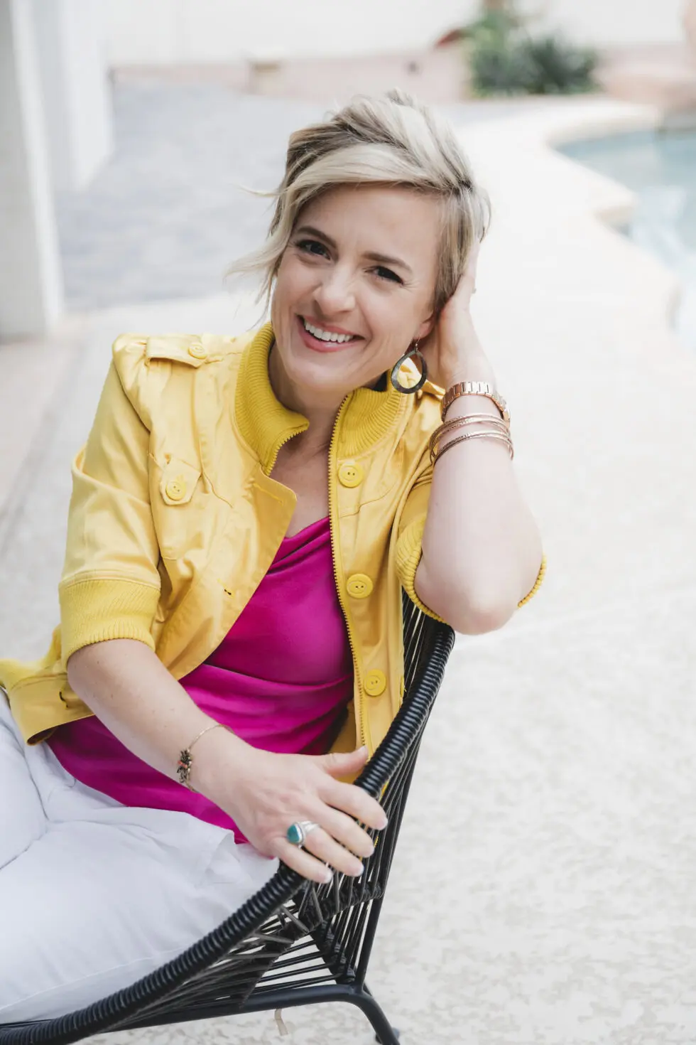 Portrait of Teresa Porter seated outdoors in a yellow jacket.