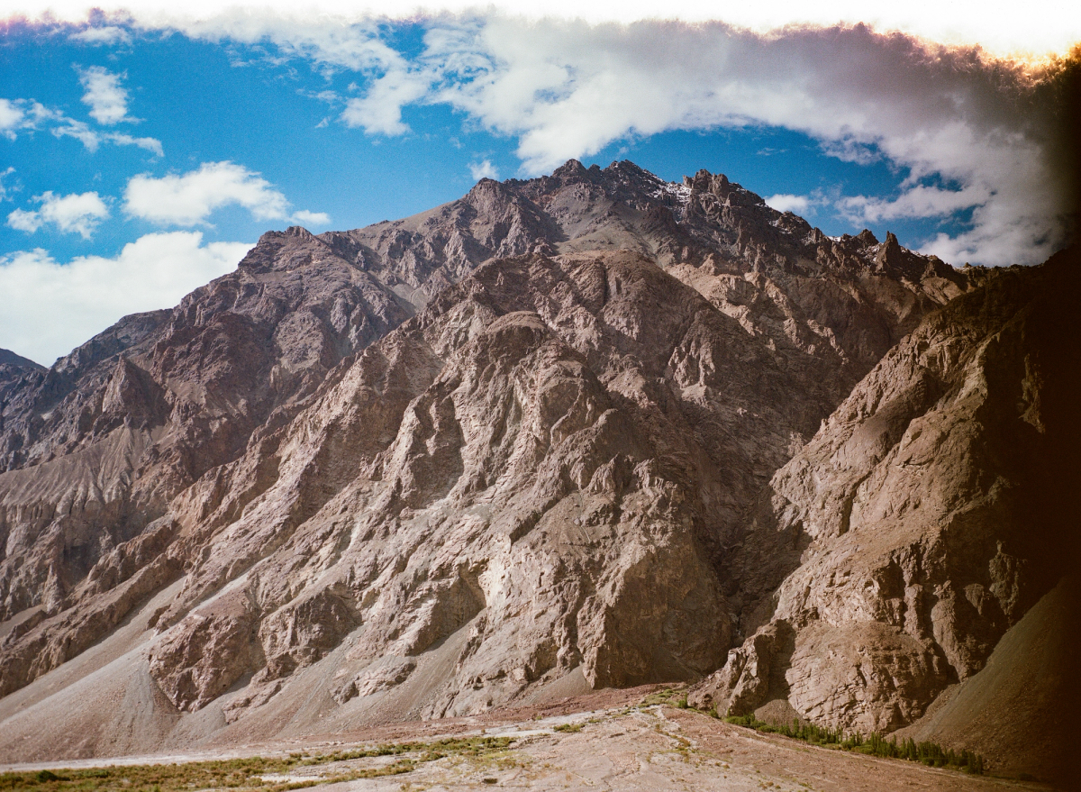 Jagged mountain peak jutting out into a sky with clouds