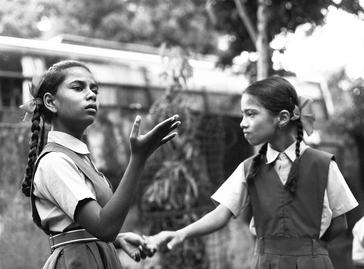 Black and white photograph of two girls in school uniforms