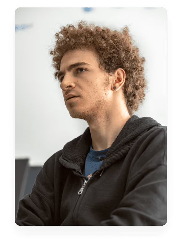 A young man with curly hair looking intently off-camera