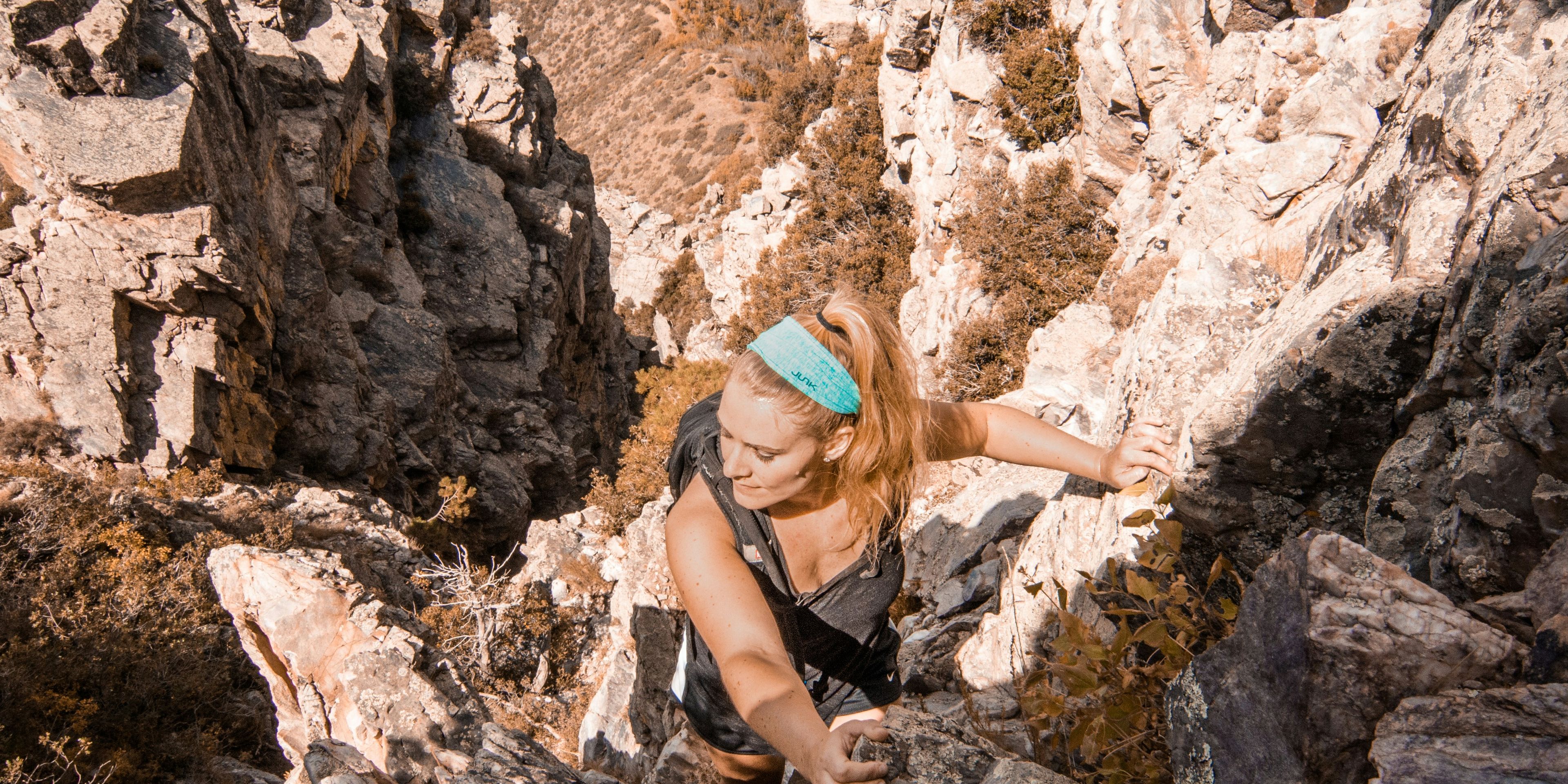 woman rock climbing and conquering mountain