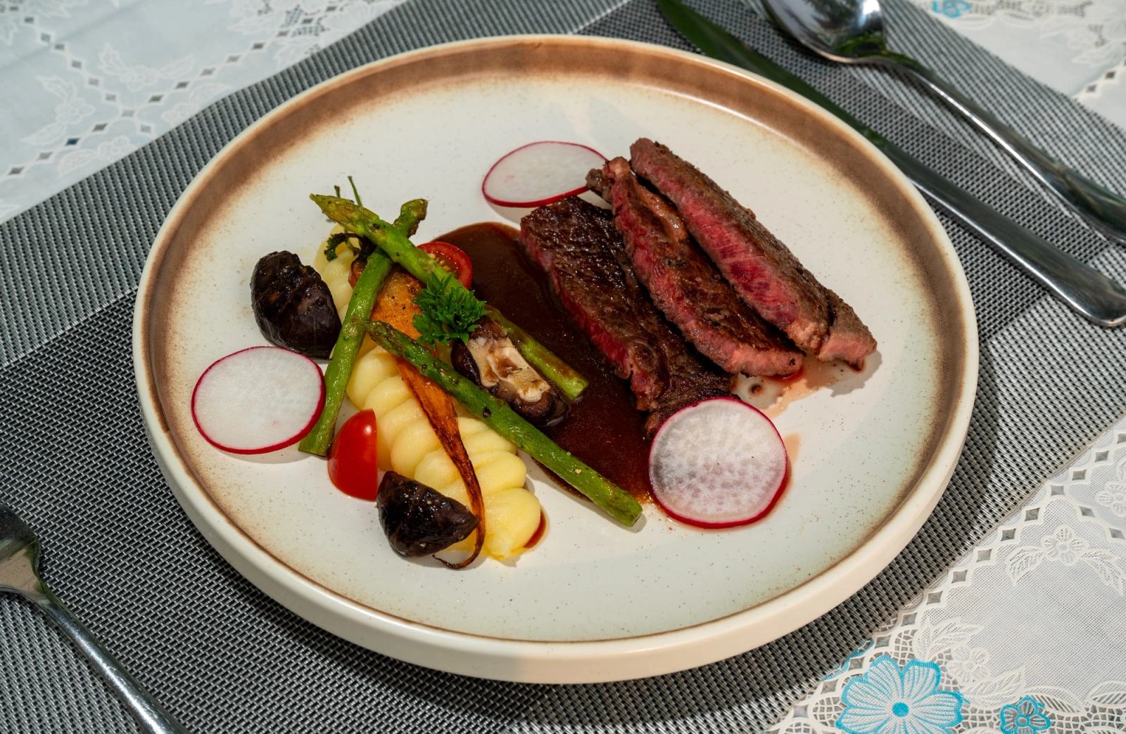 Sliced steak and vegetables on a ceramic plate at The Waterfront.