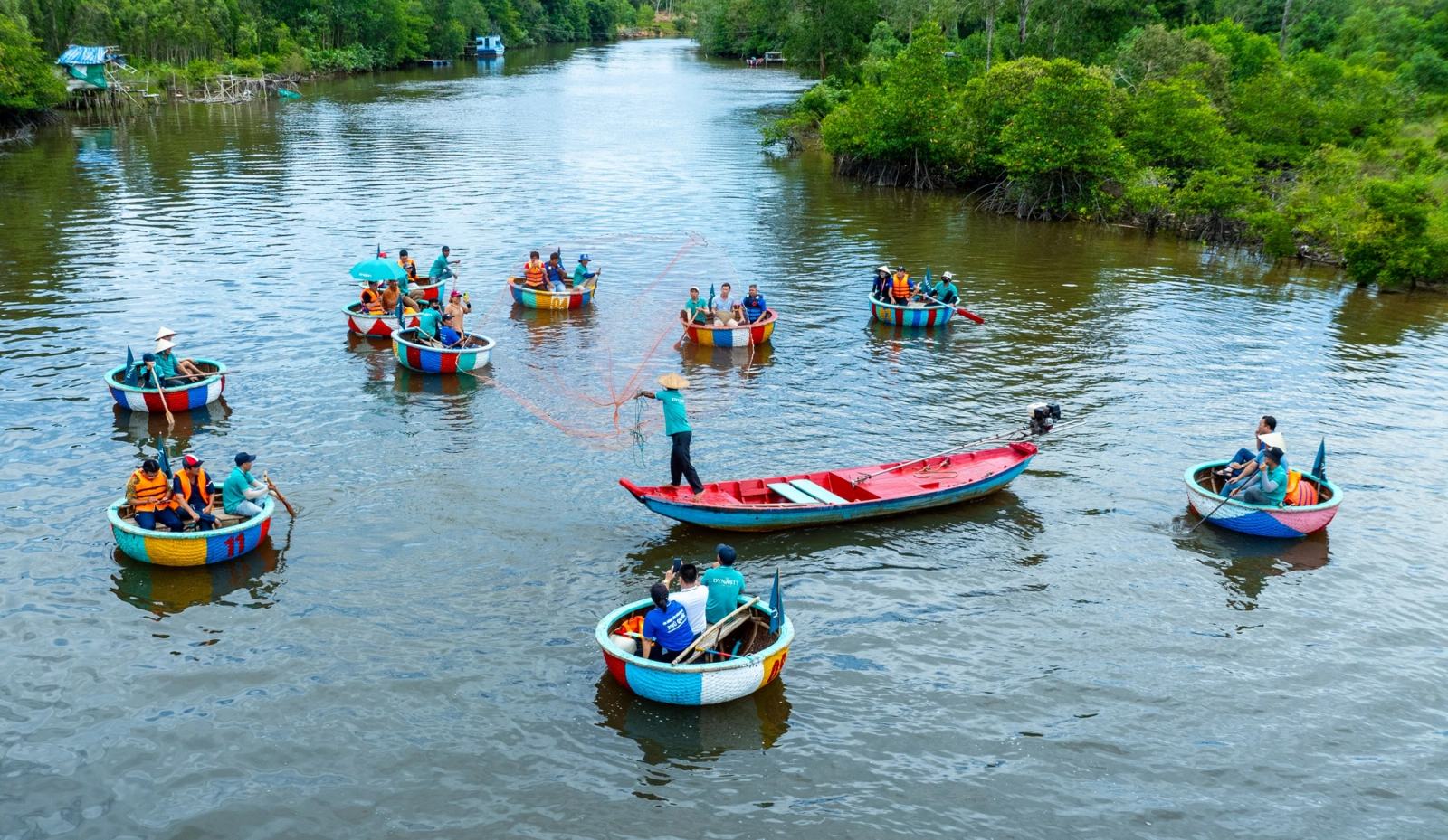 People in round boats watching a fishing-net demonstration on the river.