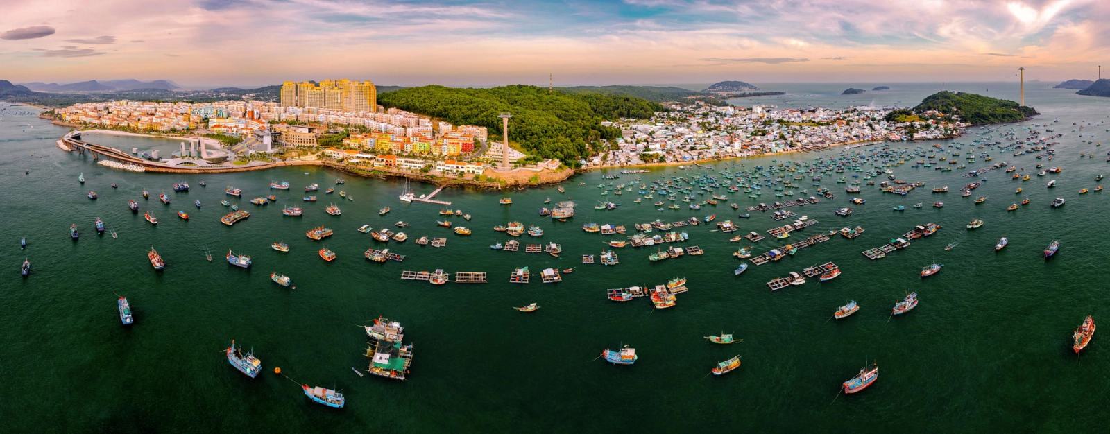 Wide aerial panorama of the harbour, boats and Sunset Town coastline.