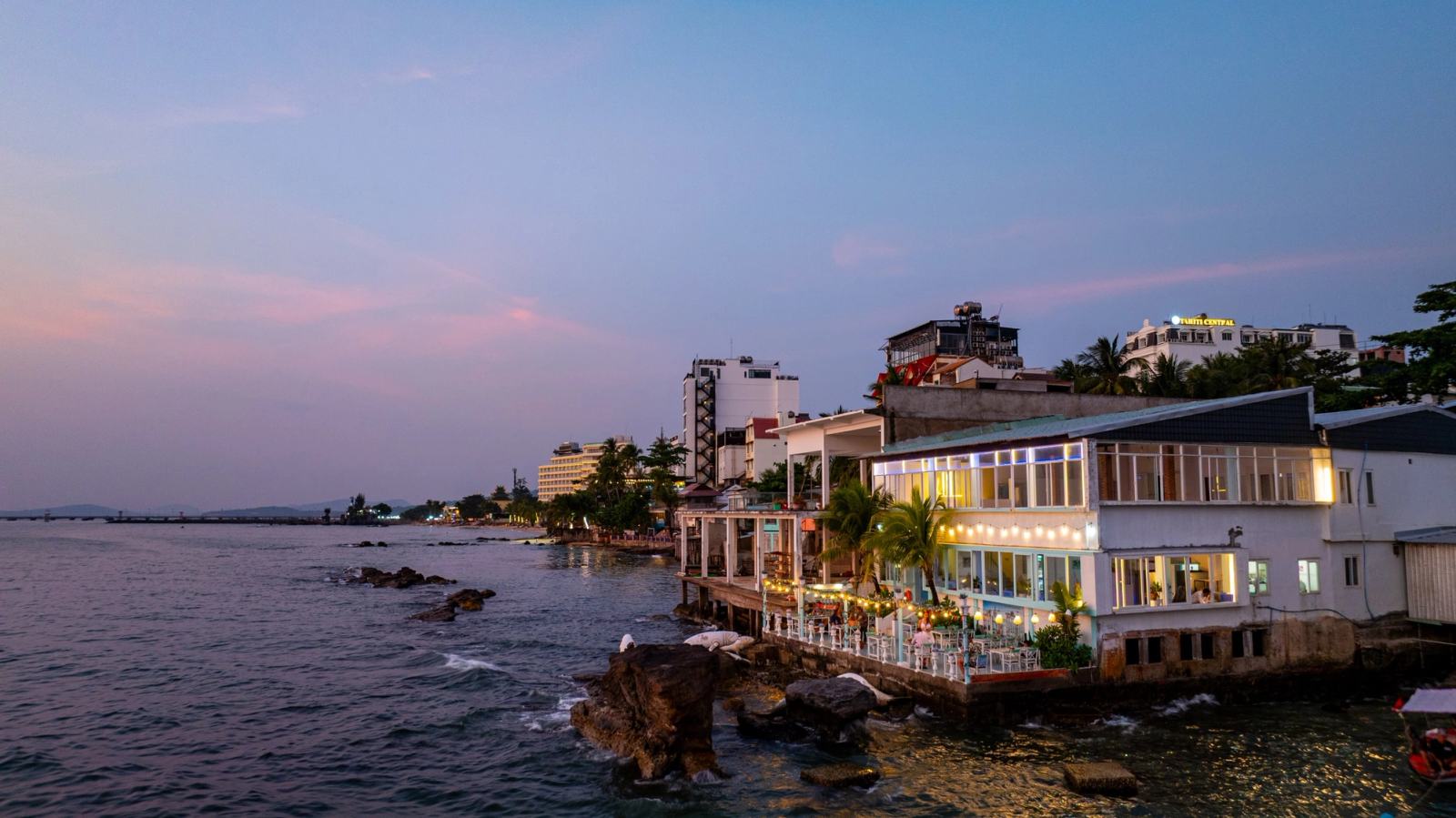 The Waterfront restaurant beside the rocky coastline at dusk.