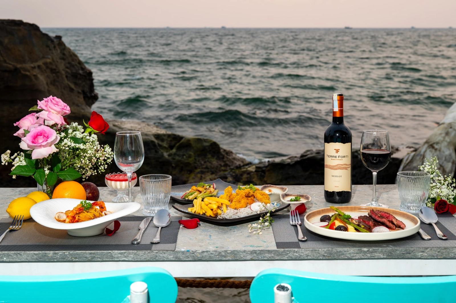 Food and table settings overlooking the rocky shoreline at The Waterfront.