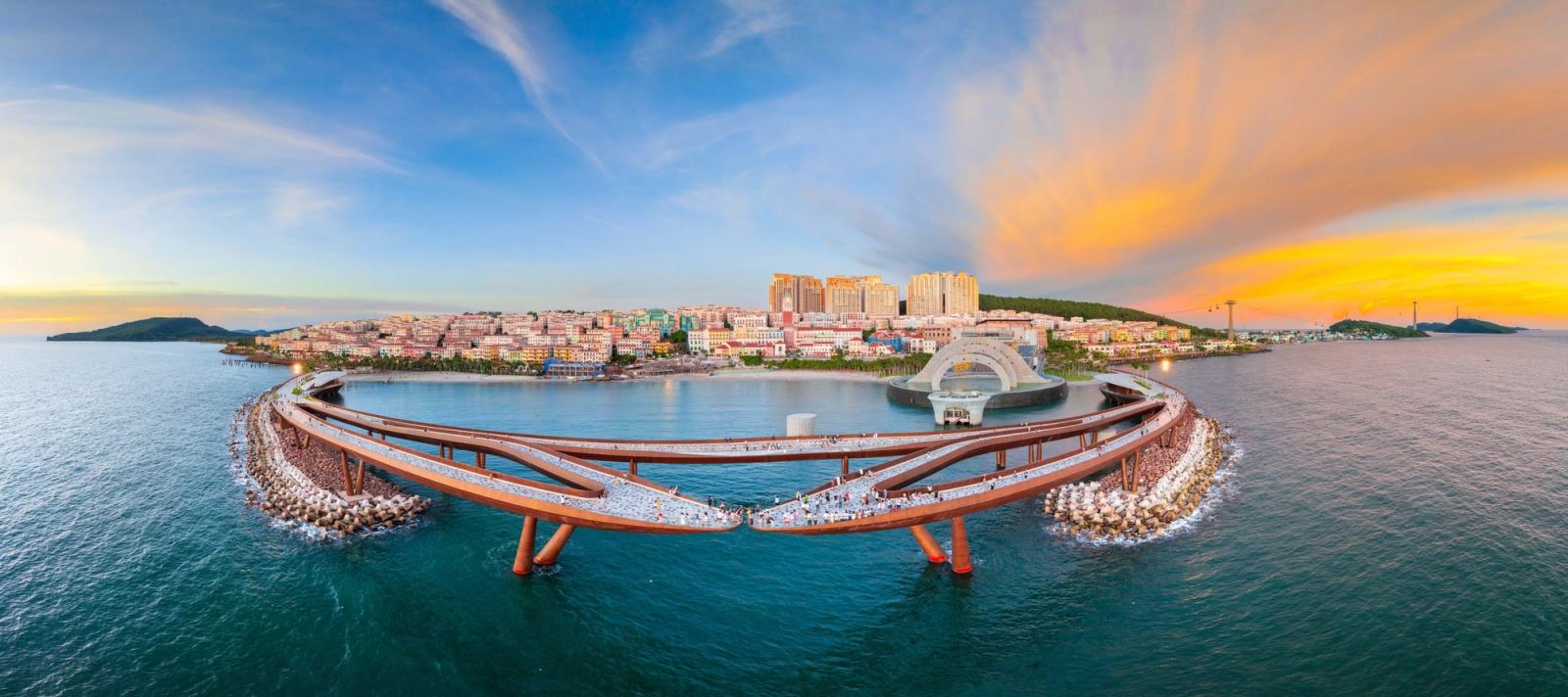 Wide view of Kiss Bridge and the waterfront beneath a warm evening sky.