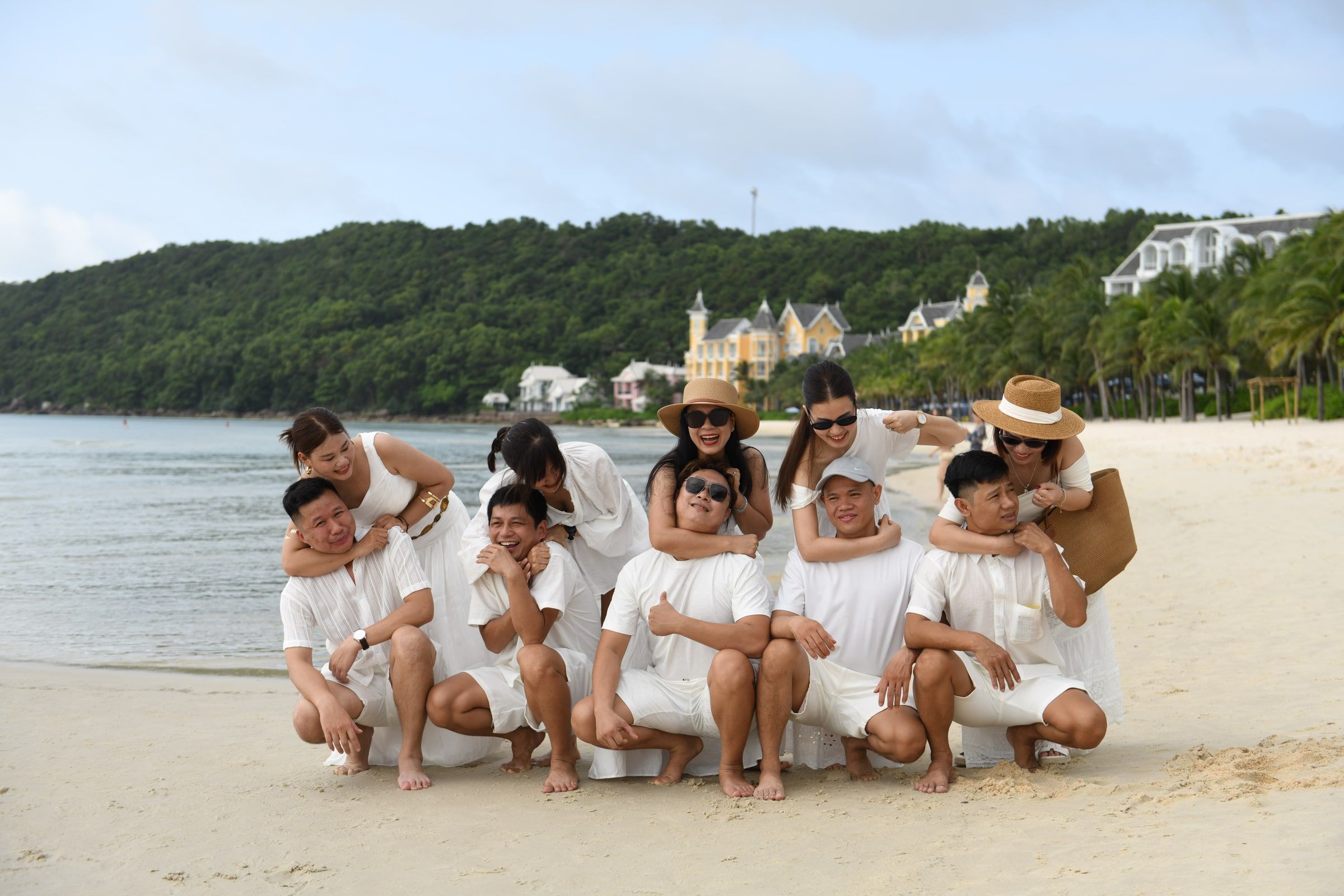 Family group sharing a playful pose together on a sandy beach.