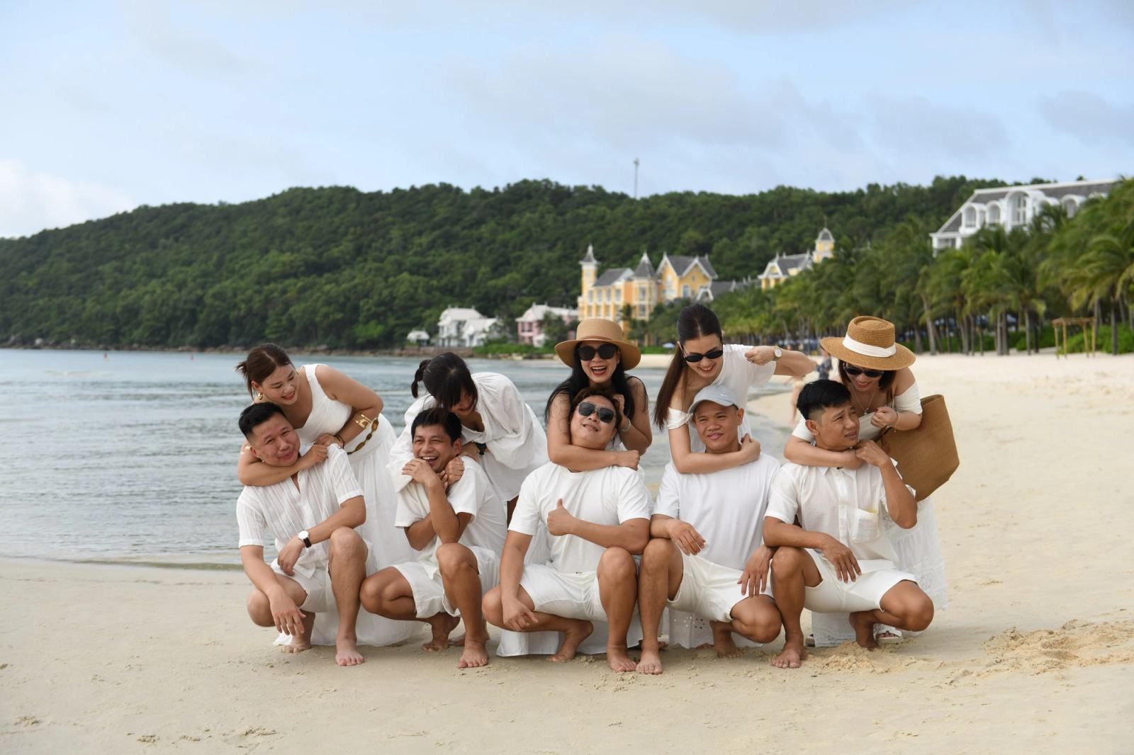 Family group sharing a playful pose together on a sandy beach.
