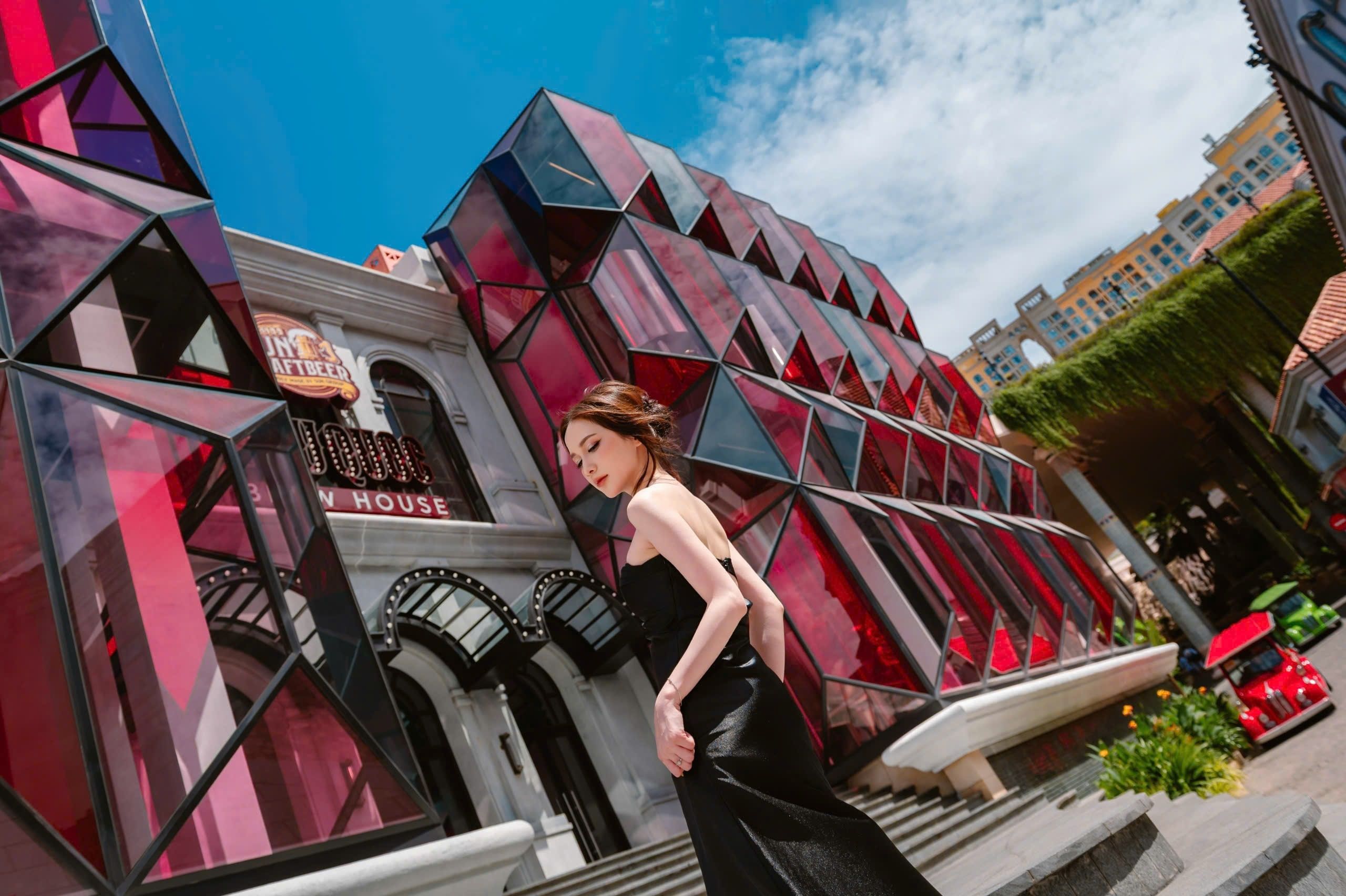 A personal portrait against red geometric architecture.