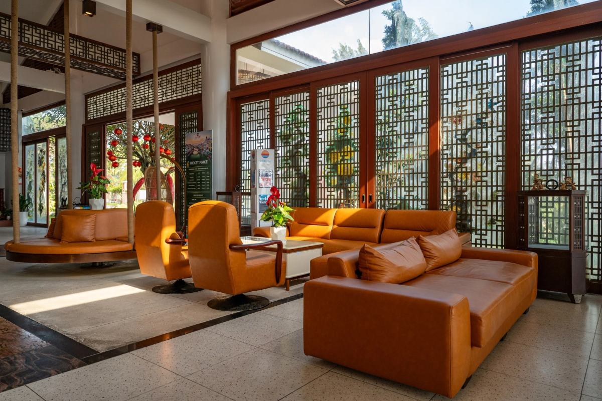 Sunlight falling across a lounge with warm-toned sofas and decorative screens.