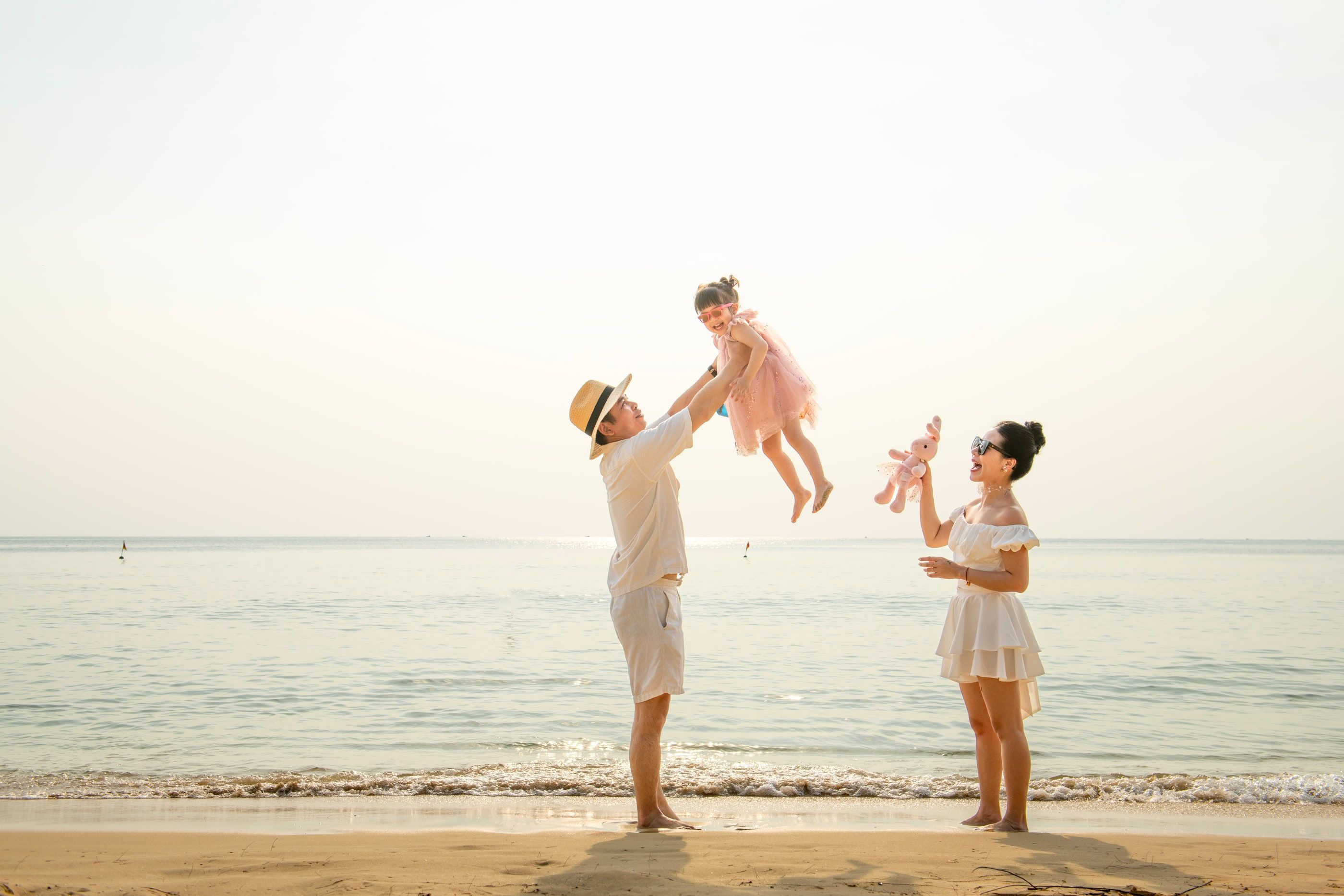 Parents playing with two children at the water’s edge.