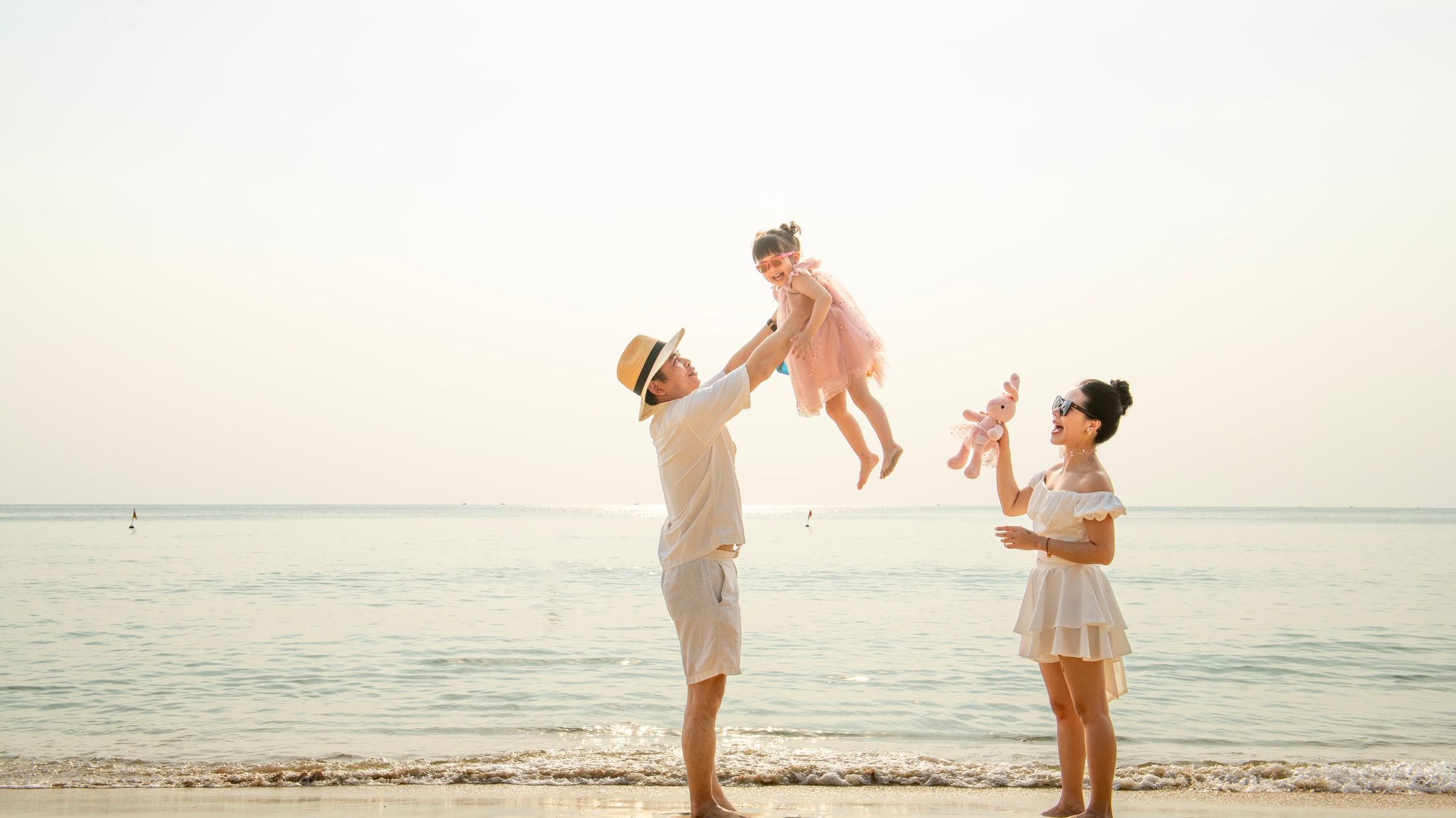 Parents playing with two children at the water’s edge.