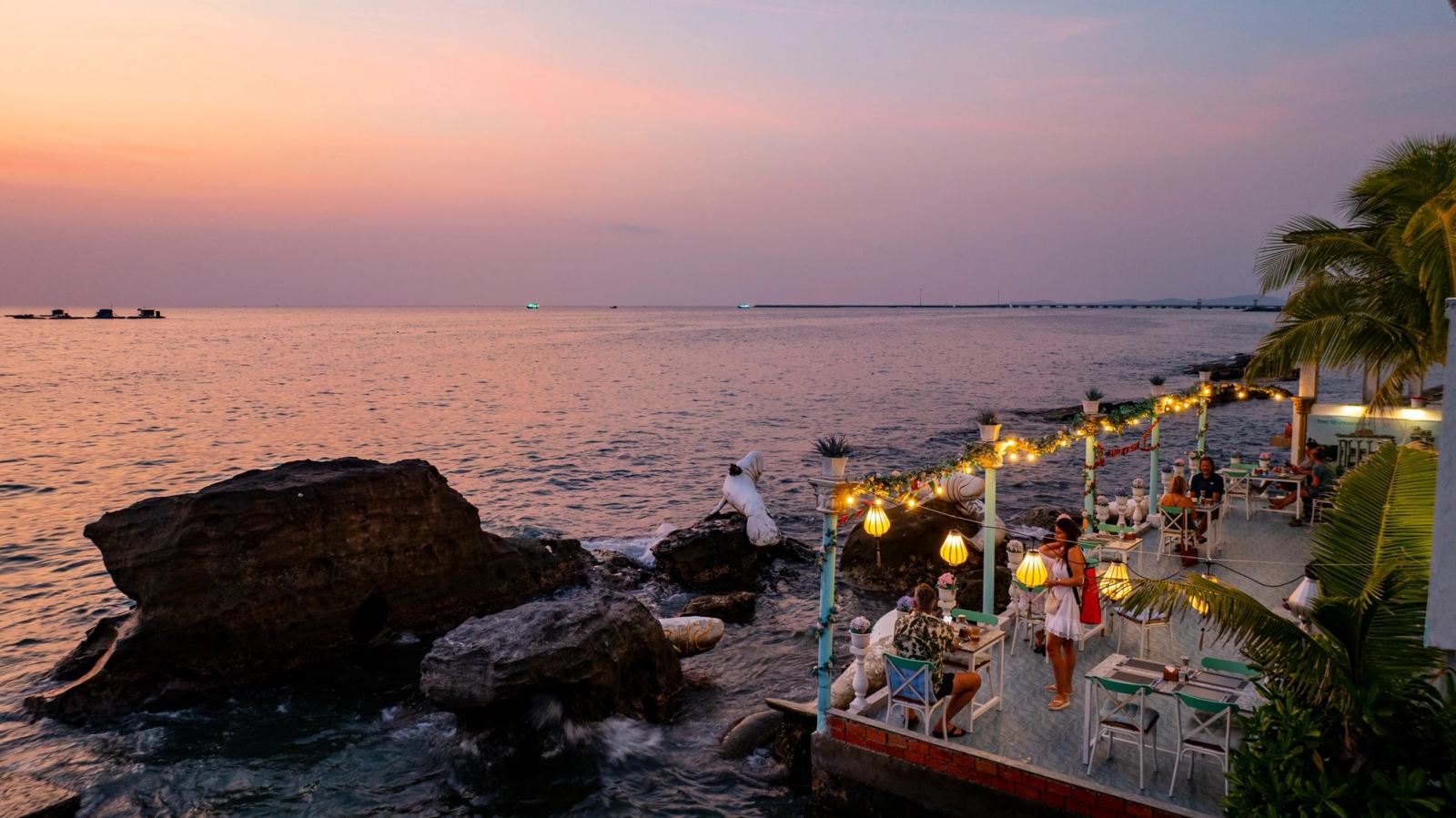 Sunset over the sea beside the illuminated Waterfront terrace.