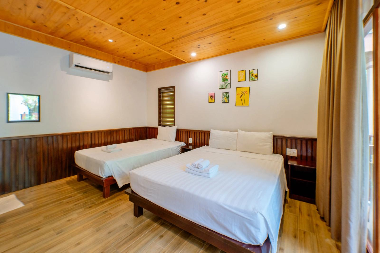 Bedroom with two beds, timber flooring and a timber-panelled ceiling.