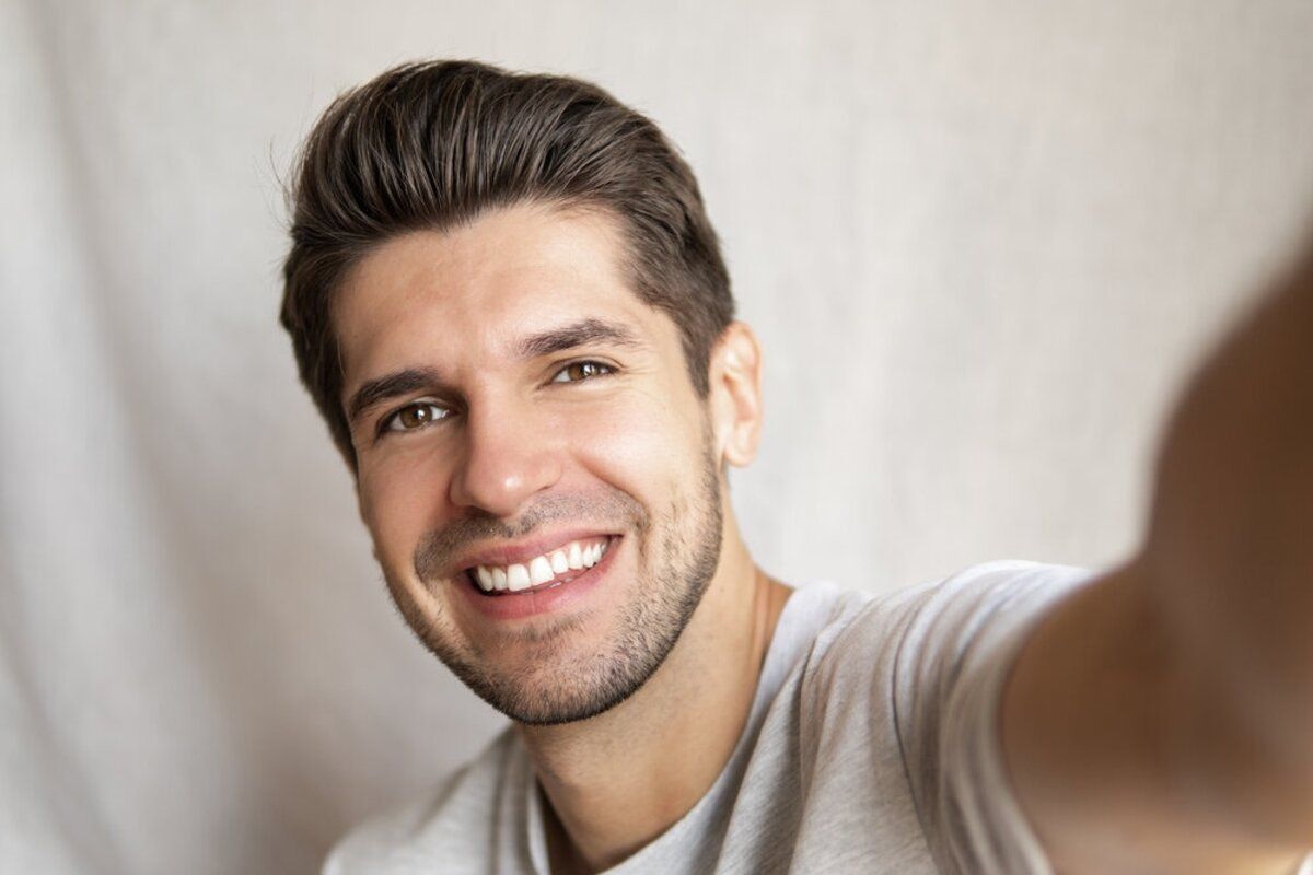 Handsome man smiles with beautiful straight white teeth from veneers in San Francisco