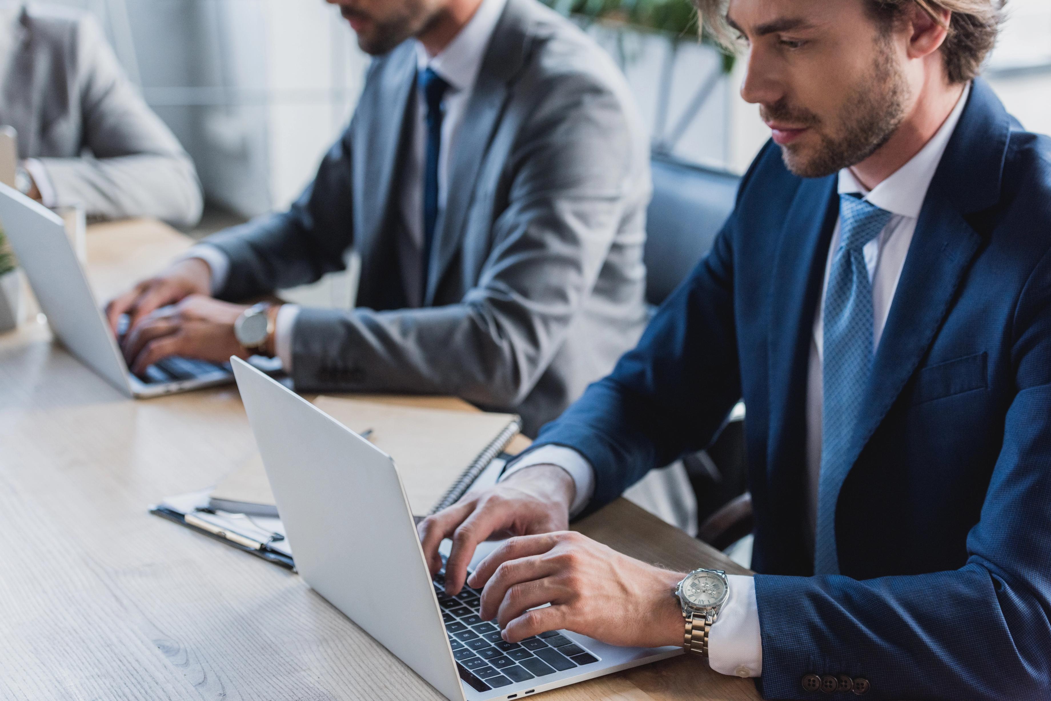 Business men working on laptops