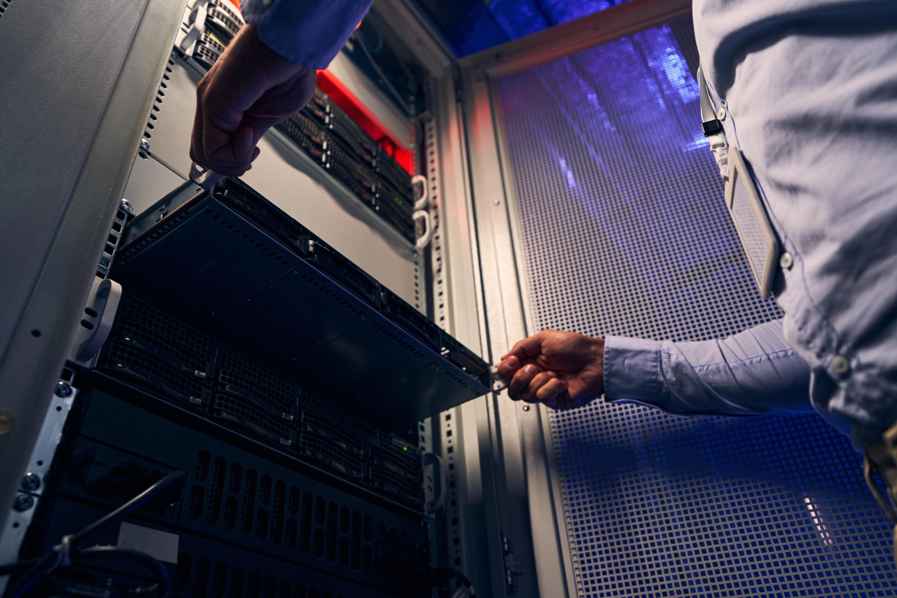 Employee pulling out server from a server rack