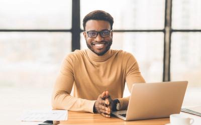 A smiling IT Director at a desk representing a non-profit organisation supported by Newcorp's Microsoft 365 Backup and Recovery service.