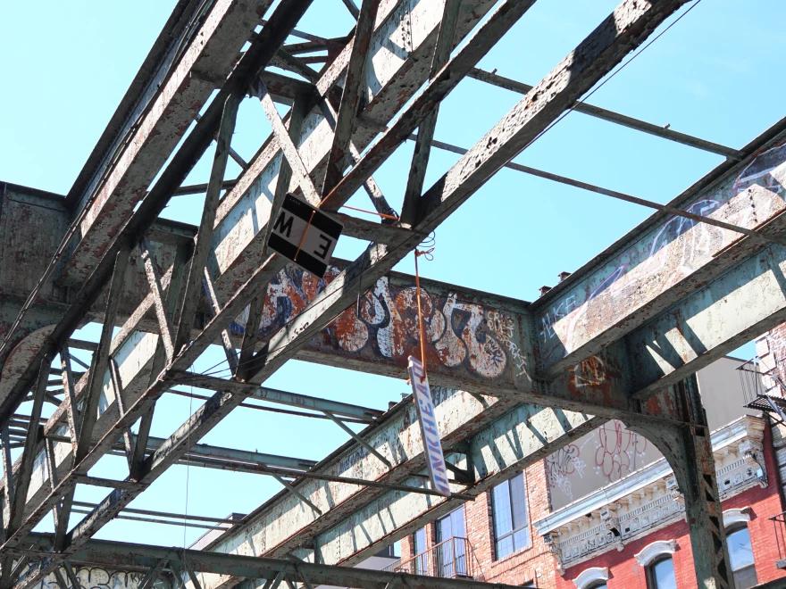 Industrial beams with graffiti on them in a city.