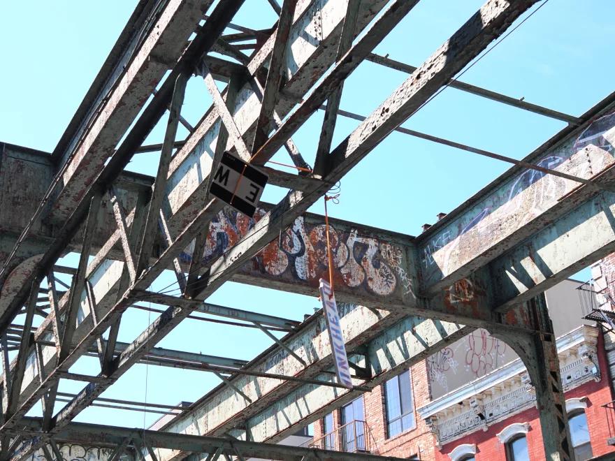 Poutres industrielles couvertes de graffitis dans une ville.